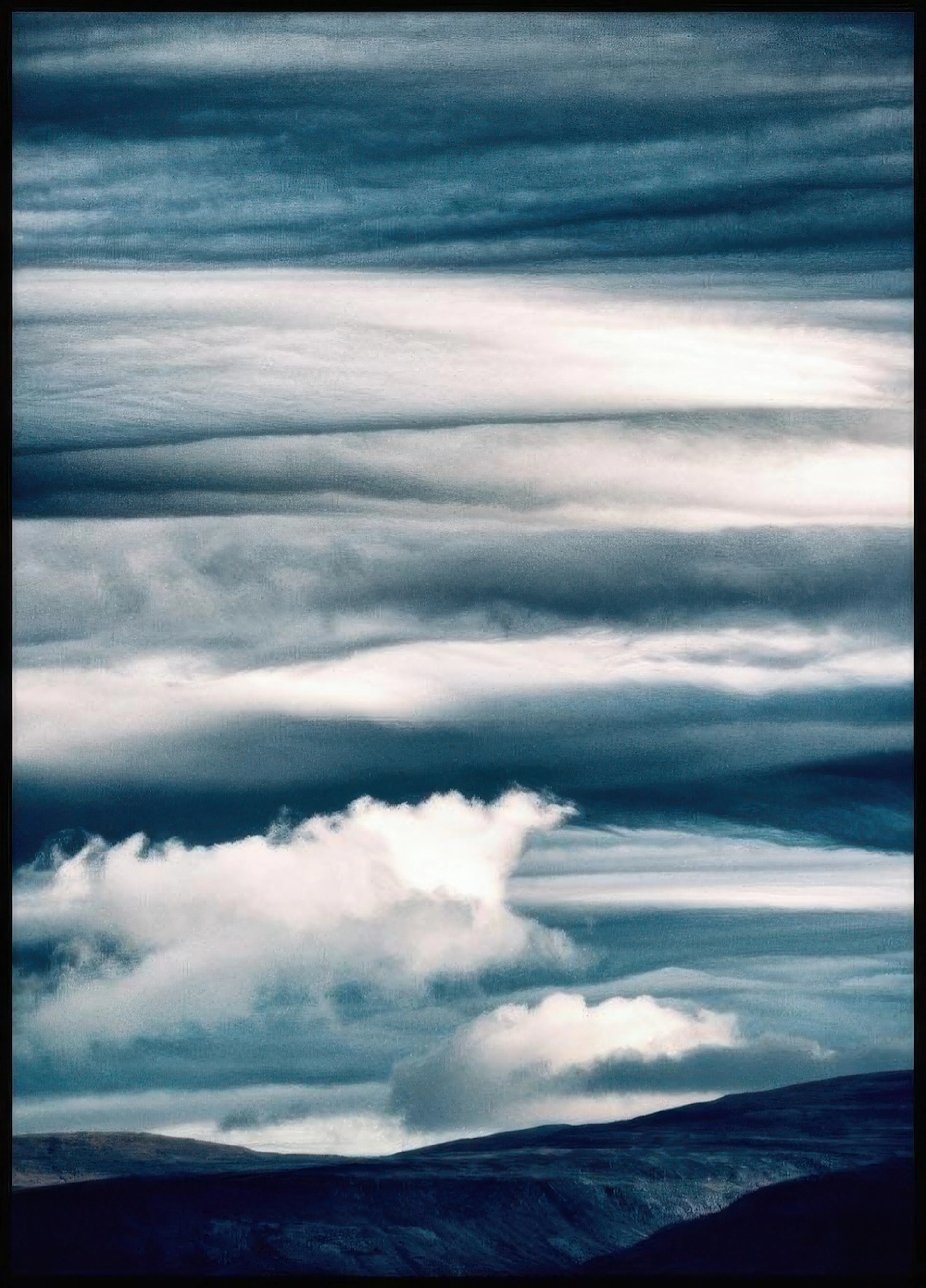 Plakát zobrazuje vrstvené tmavě modré a šedobílé oblačné formace nad tmavou krajinou.
