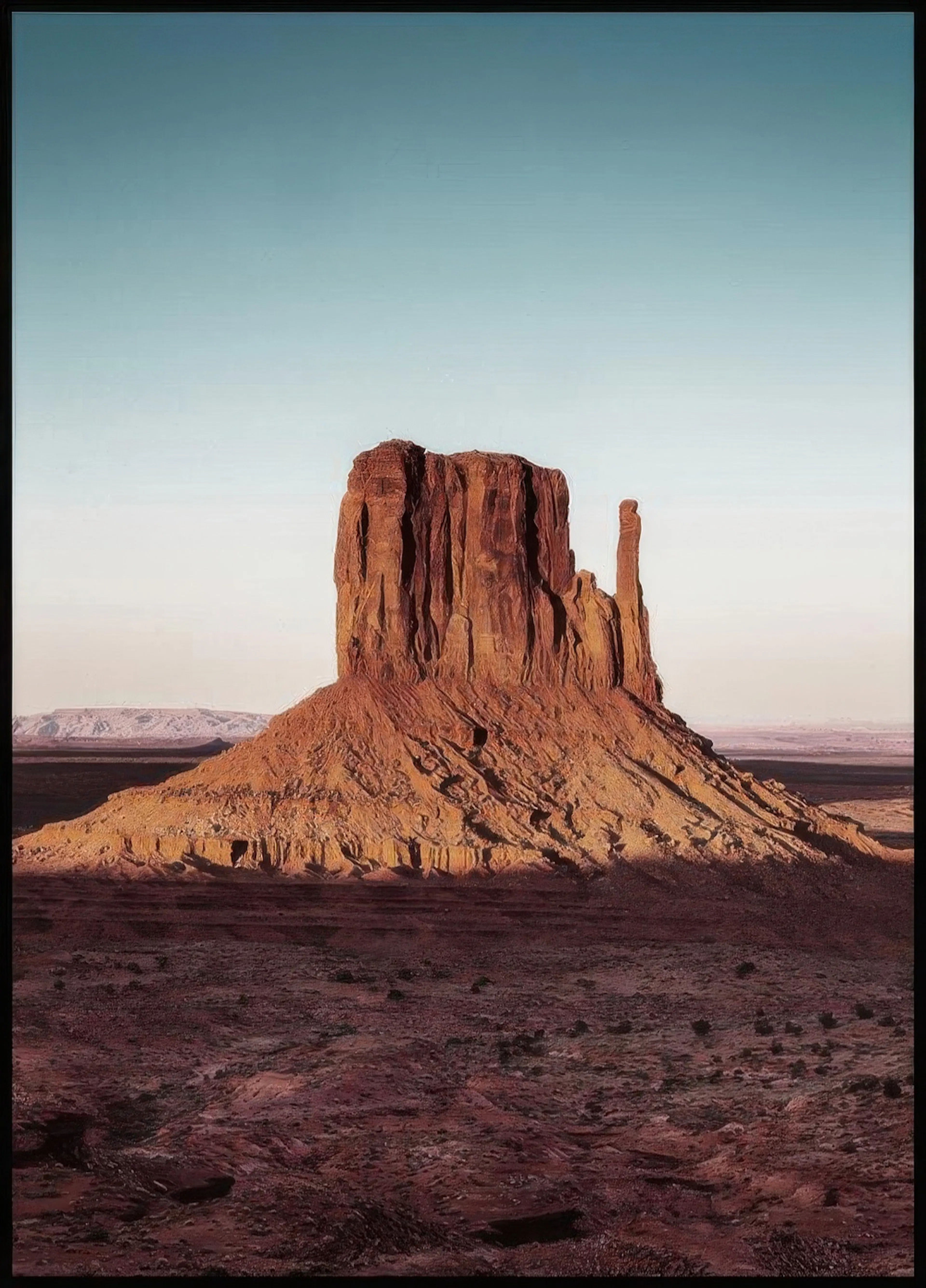 A poster featuring a large, sunlit red rock formation in a desert landscape under a clear sky.