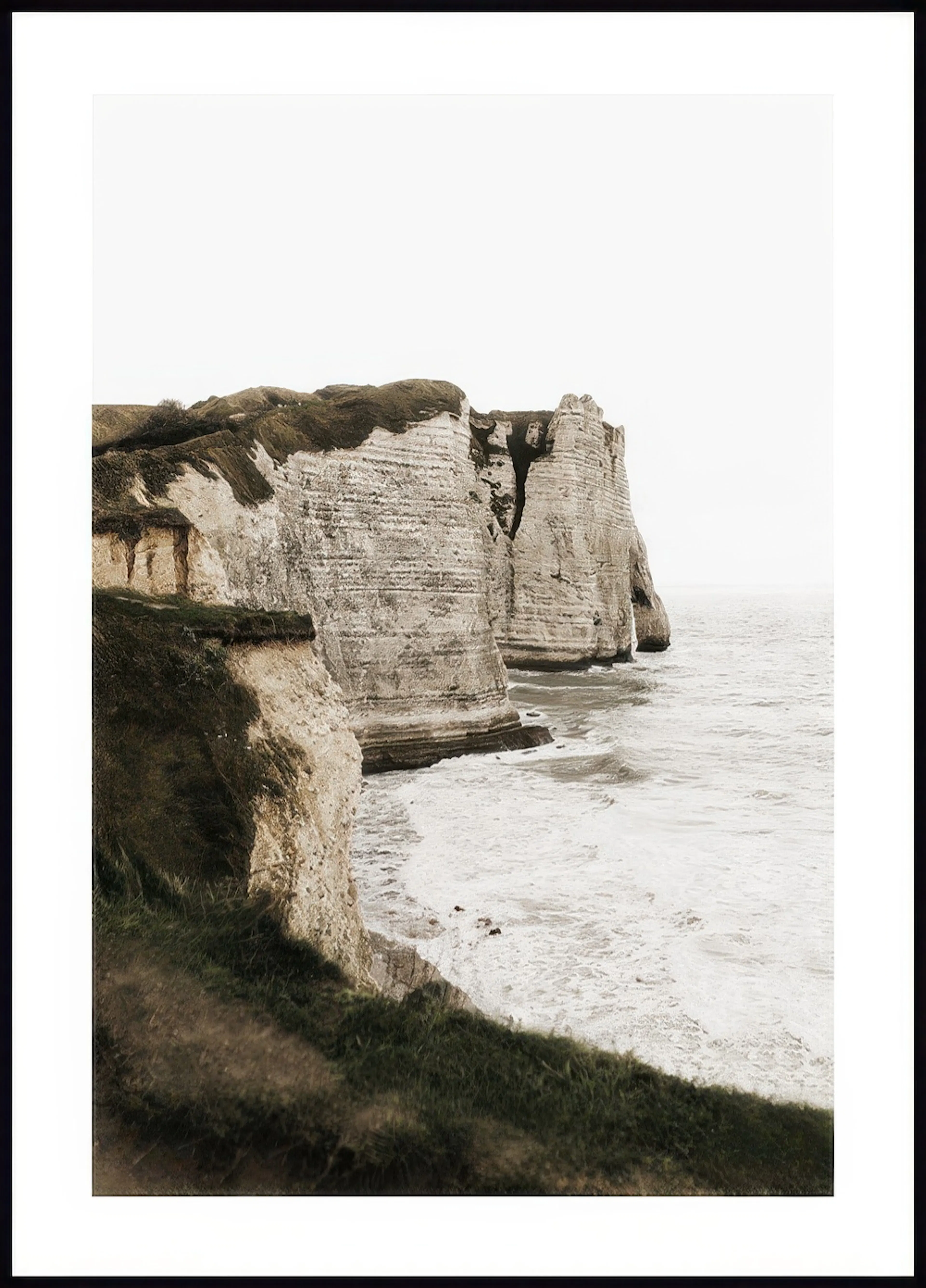 Un poster des falaises dÉtretat en Normandie, avec la mer et la végétation en premier plan.