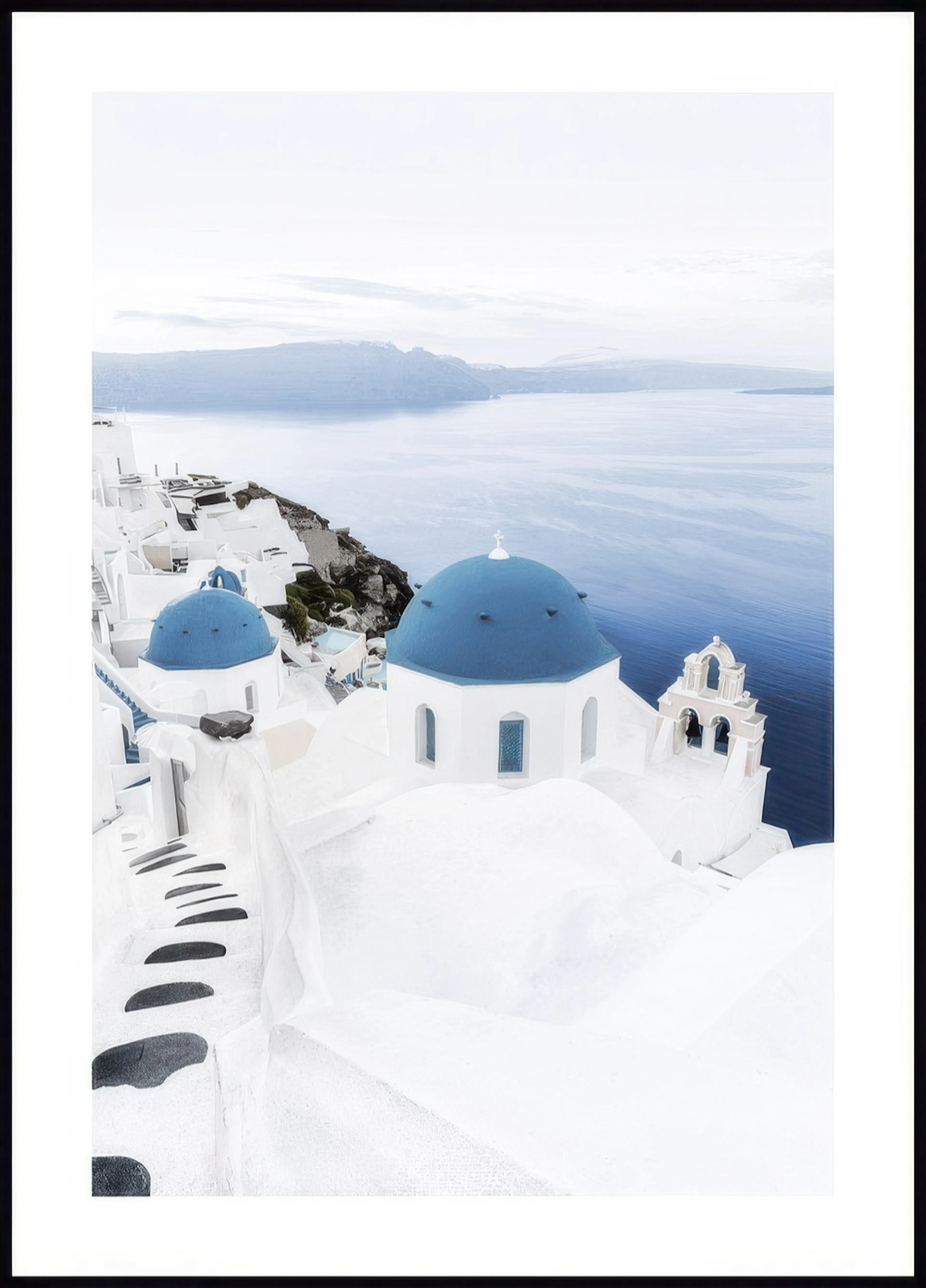 A poster depicting white buildings with blue domes and a bell tower overlooking a calm blue sea and distant mountains.