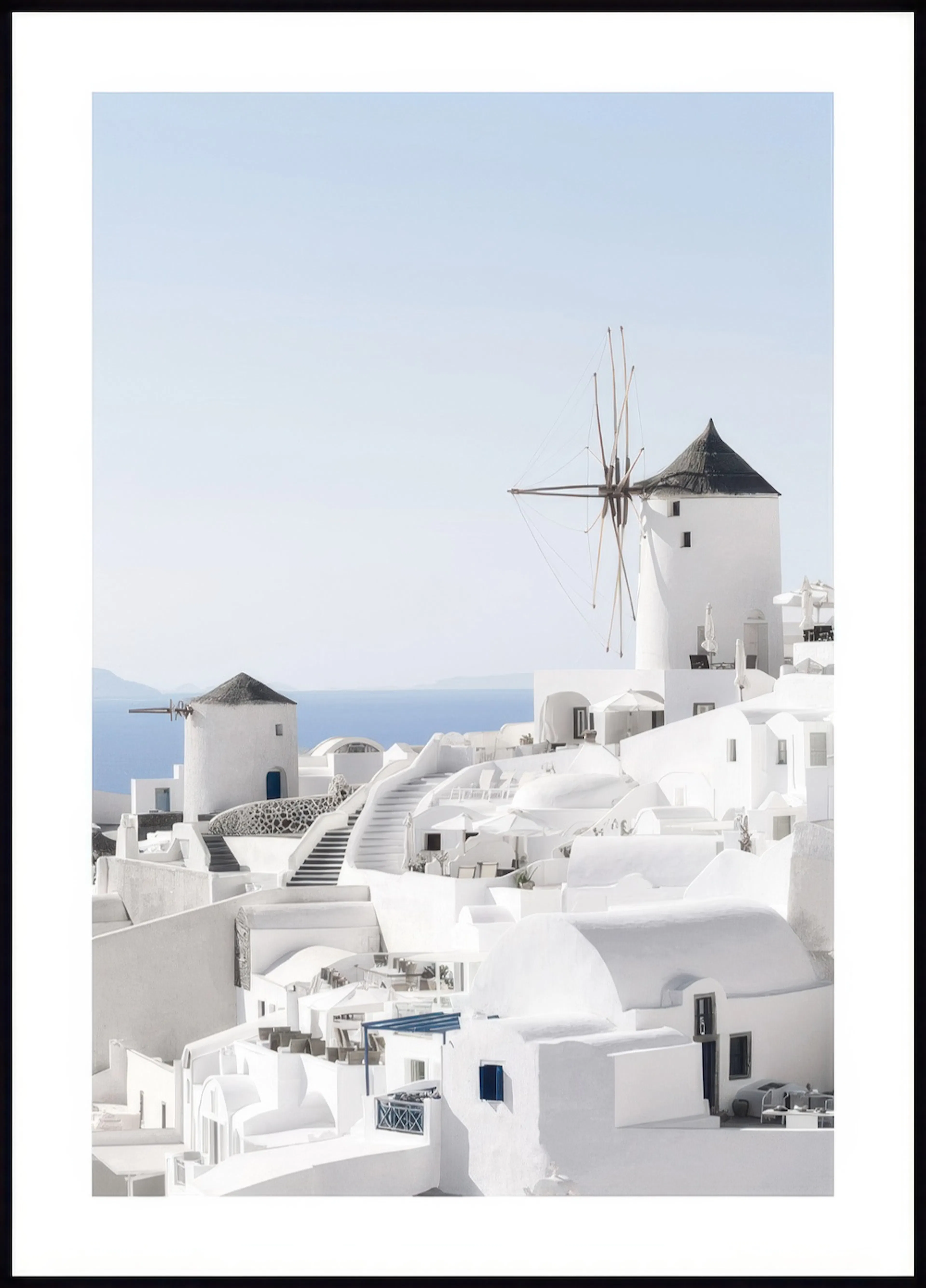 A poster featuring iconic white buildings and windmills overlooking the blue sea in Santorini, Greece.