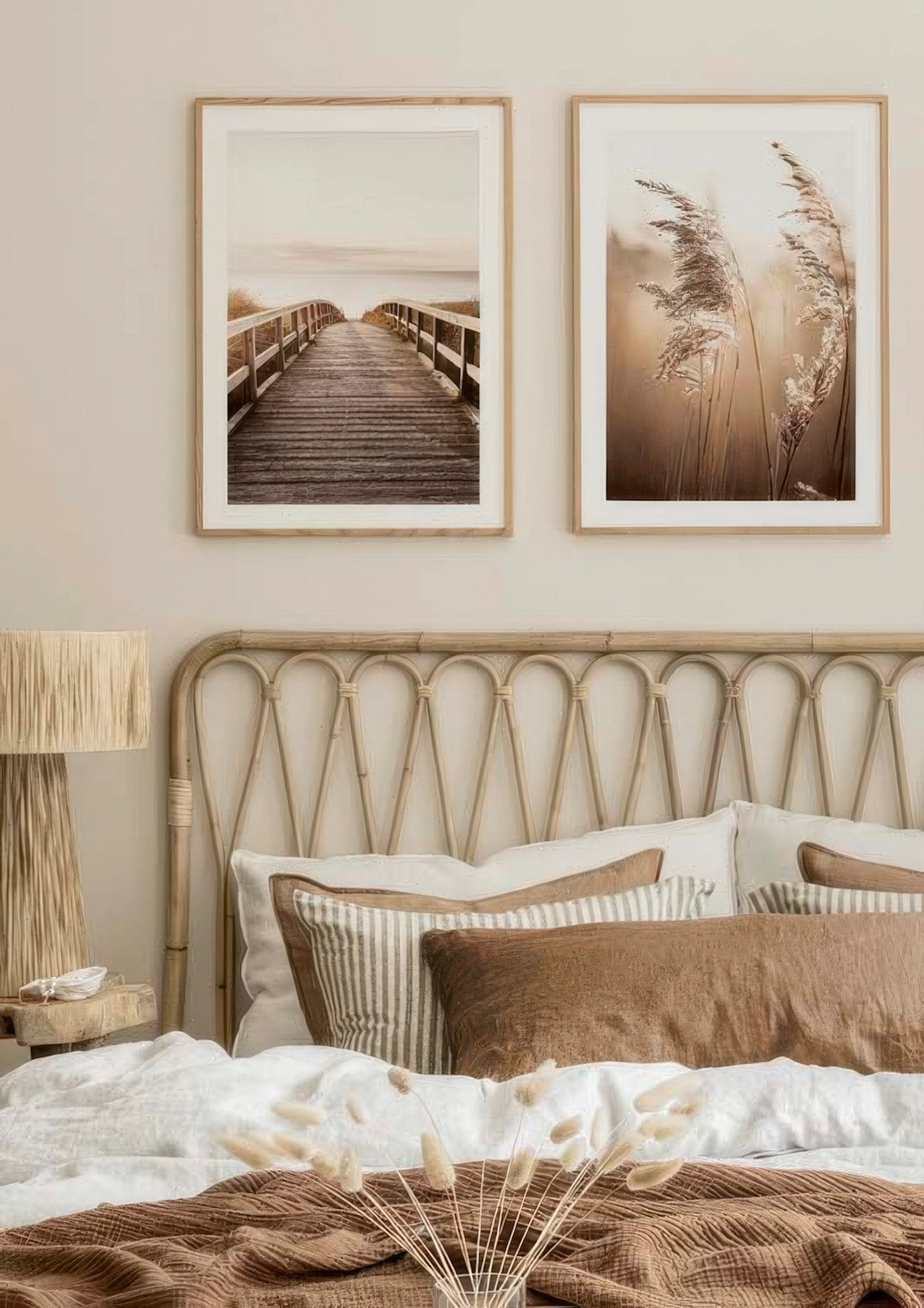 Ein Posterset mit zwei Motiven: einem Holzsteg zum Meer und goldenen Gräsern im Sonnenlicht, über einem Bett.