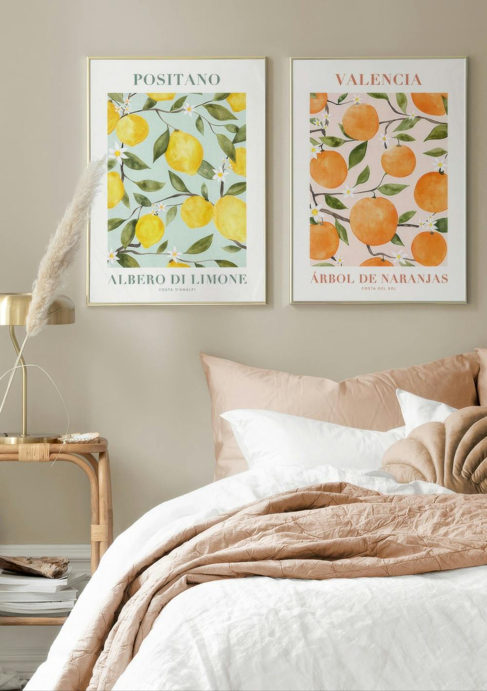 Sada plakátů s ilustracemi citronů a pomerančů s listy a květy nad postelí v ložnici.