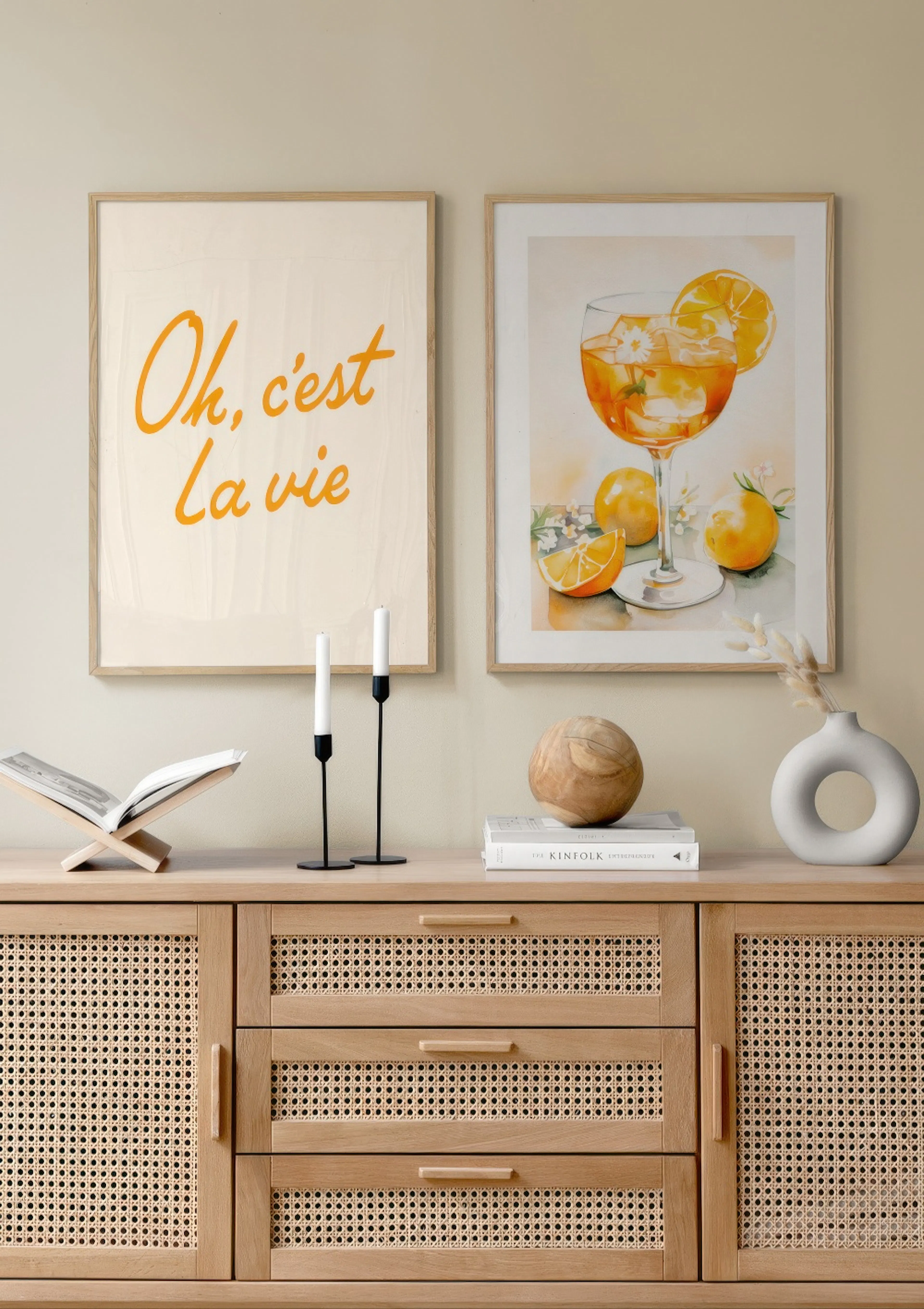 En plakatpakke med to plakater: en med teksten Oh, cest La vie i orange skrift, og en akvarel af en Aperol Spritz med appelsiner
