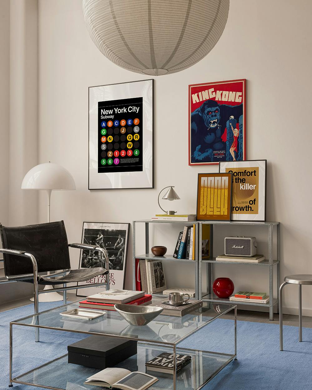 A gallery wall with a black New York City subway map print, a red King Kong poster, and two yellow and black typographic prints.