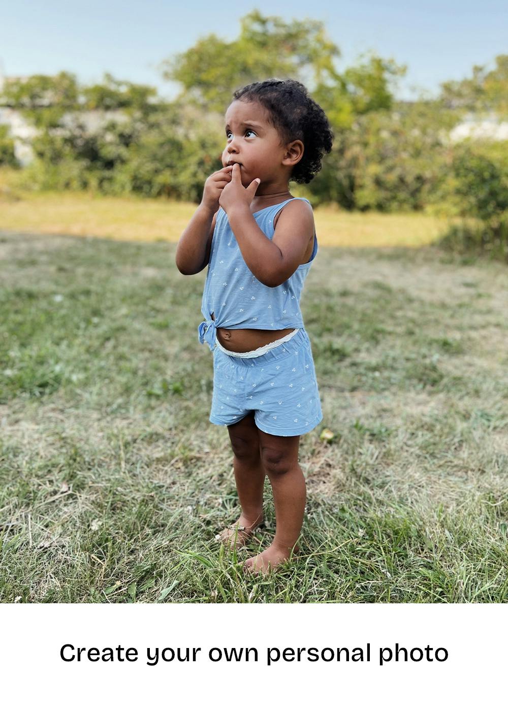 En poster av ett litet barn i blå kläder som står barfota i gräset och tittar uppåt.