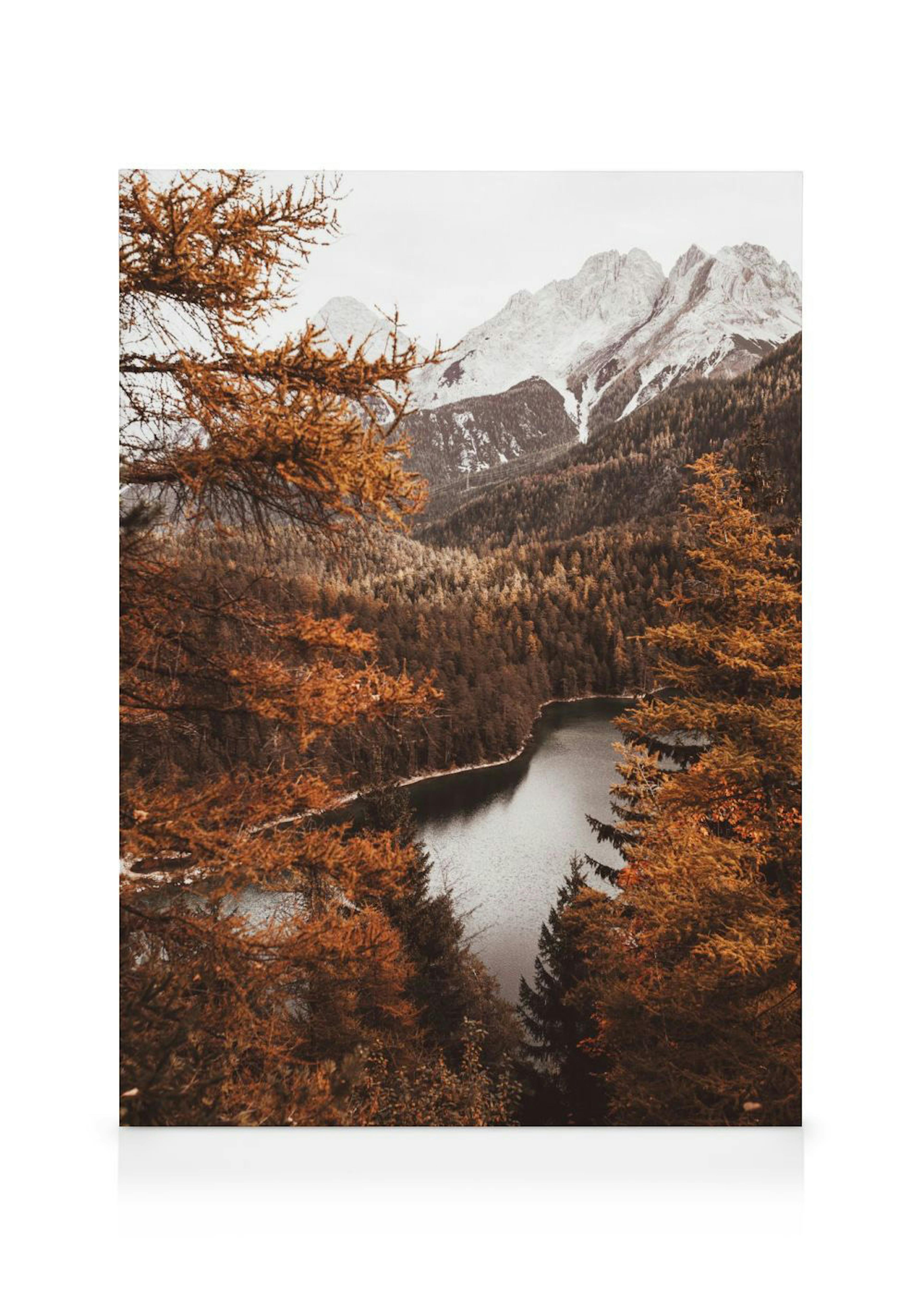 Leinwandbild: Ein Herbst-Bergsee in den Alpen, umgeben von orangefarbenen Bäumen und schneebedeckten Gipfeln.