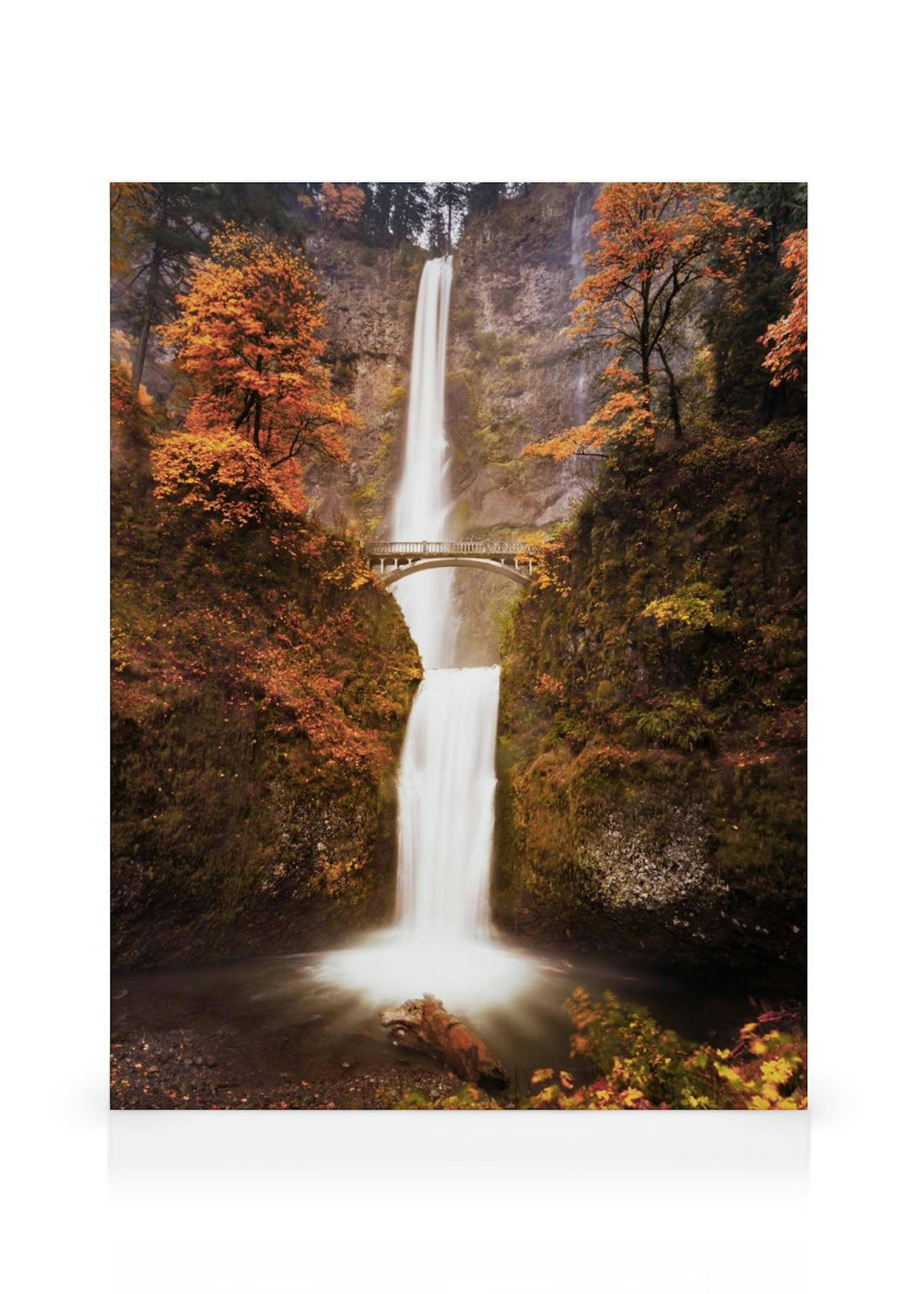 A canvas displaying Multnomah Falls in autumn, with white cascading water, a stone bridge, and vibrant orange and red foliage.