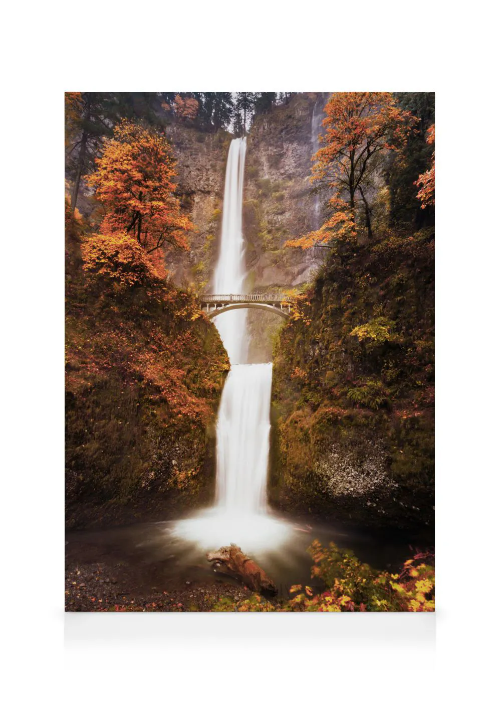 A stunning canvas of a tall waterfall with a bridge crossing it, surrounded by autumn trees with orange leaves.