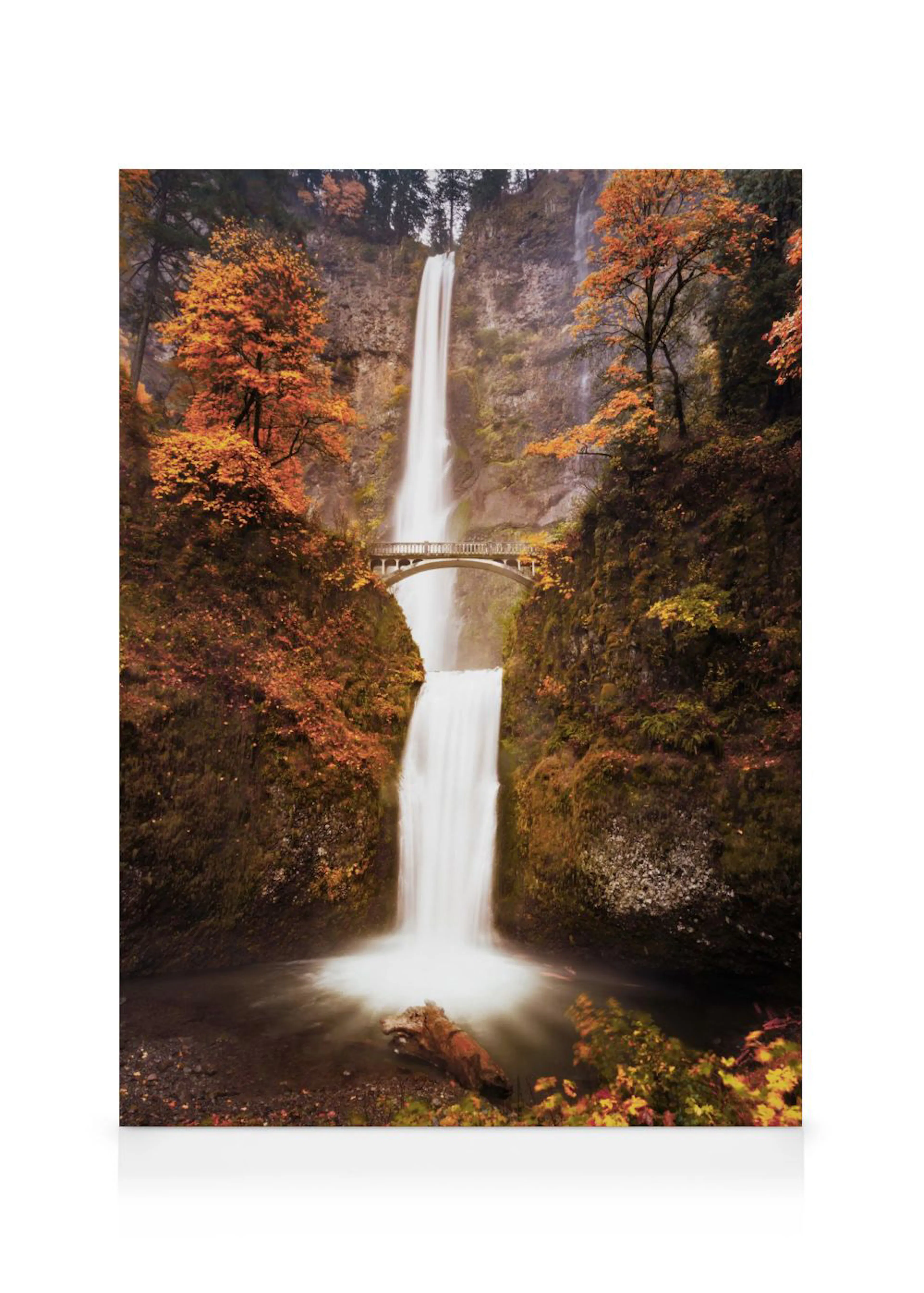 A stunning canvas of a tall waterfall with a bridge crossing it, surrounded by autumn trees with orange leaves.