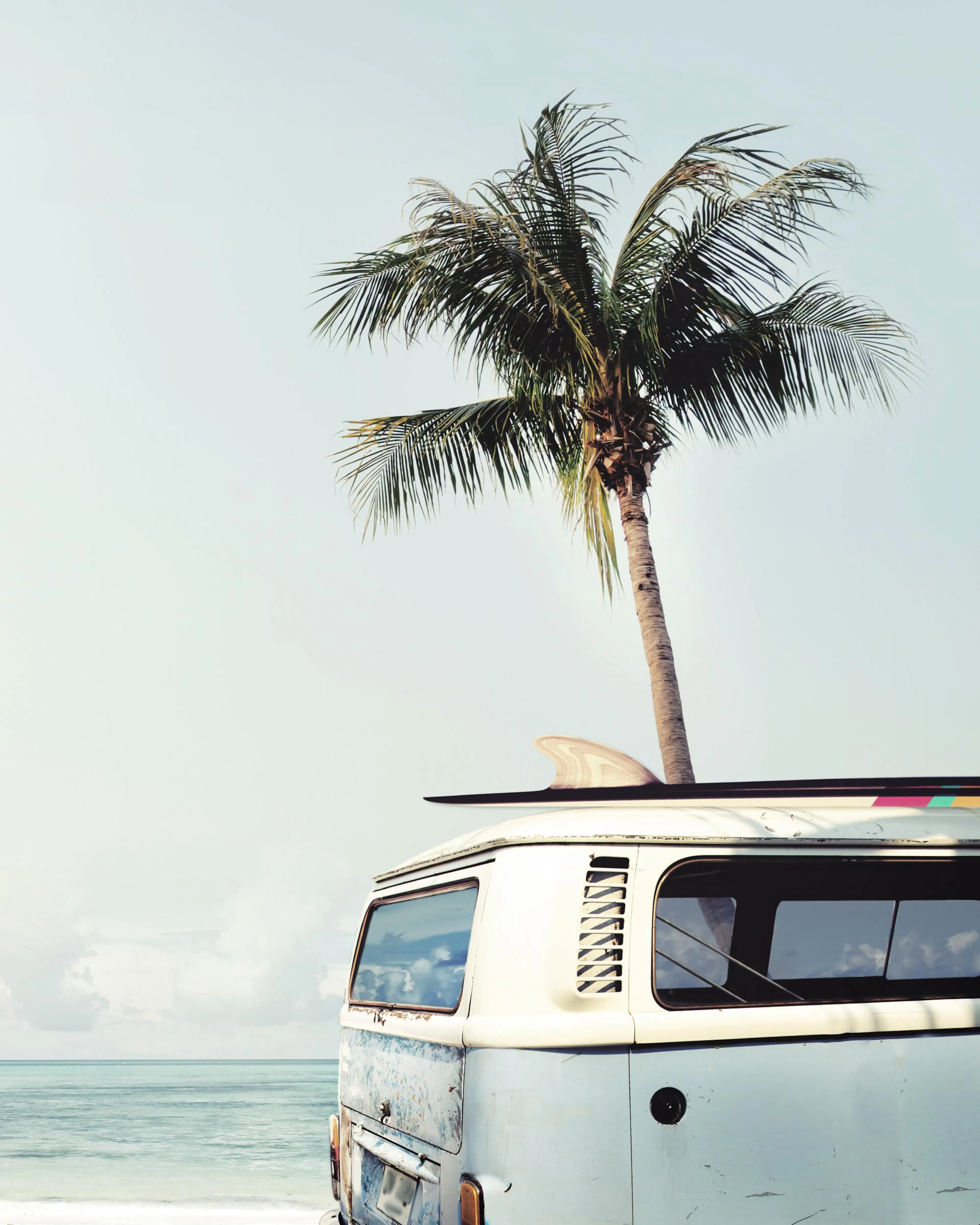 A poster featuring a vintage surf van on a beach with a palm tree and surfboard, ready for adventure.