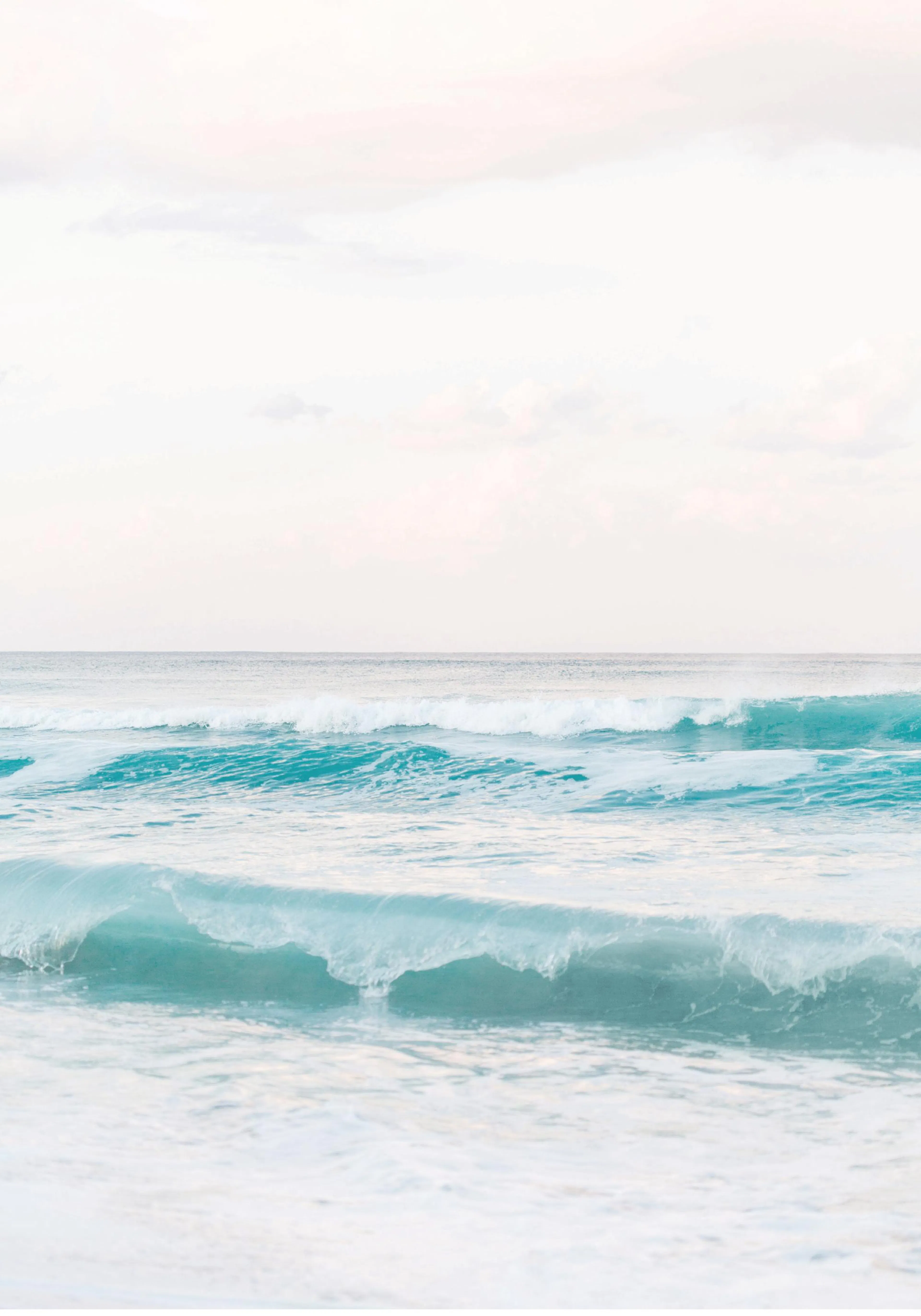 A poster featuring vibrant turquoise ocean waves rolling towards the shore under a soft white sky.