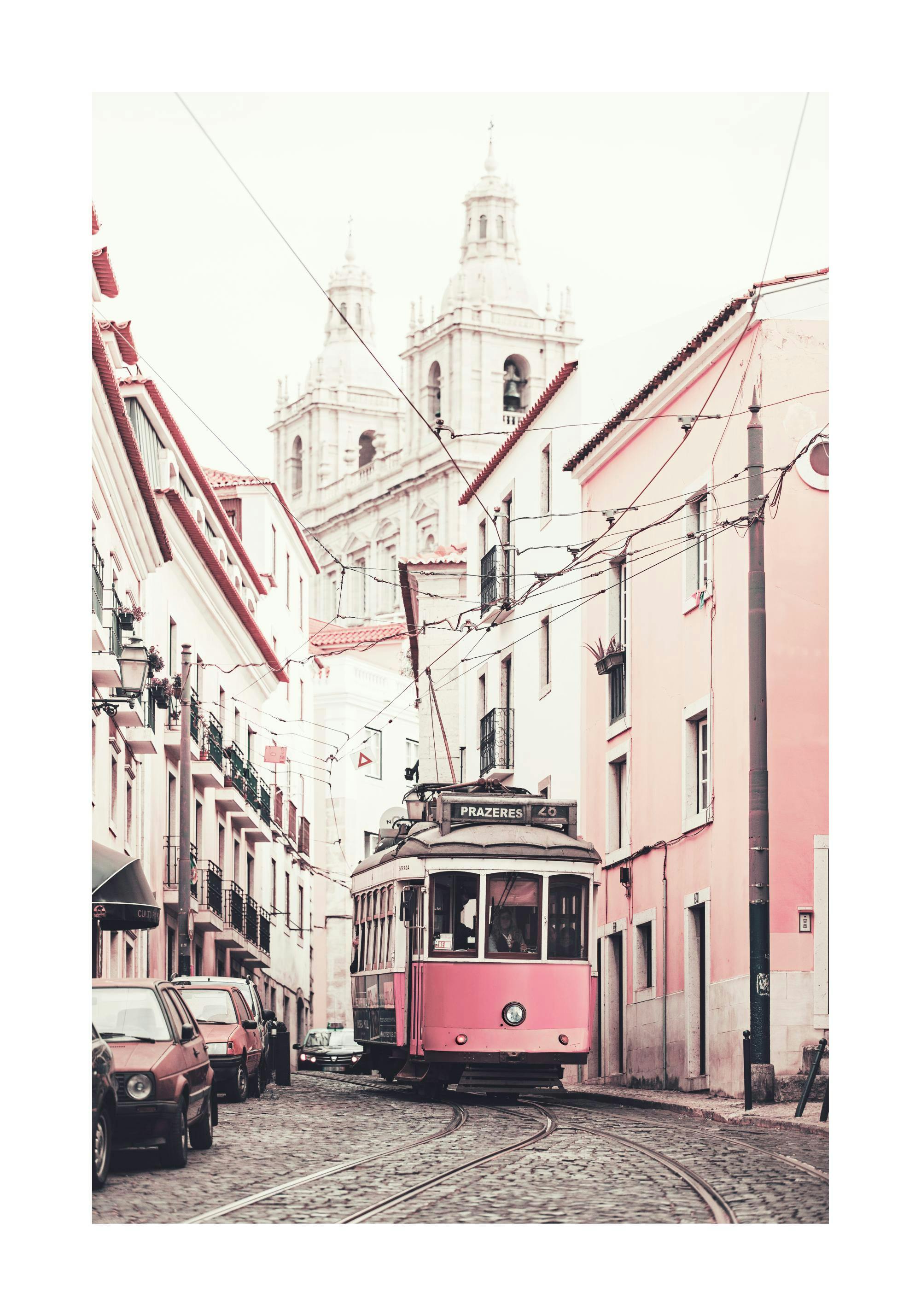 A poster featuring a vintage pink tram on a cobblestone street in Lisbon, with historic buildings and a church in the background