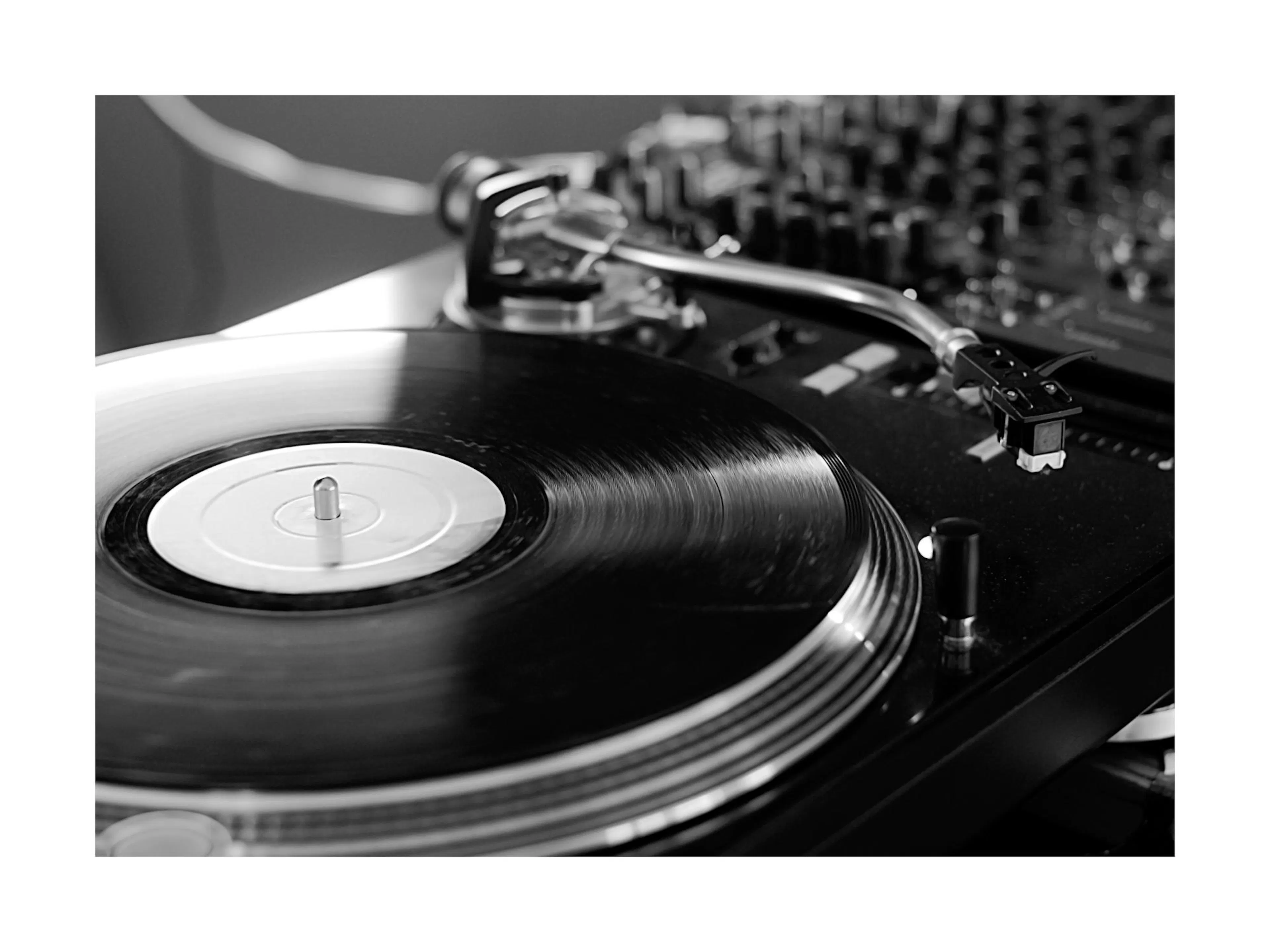Schwarz-weiß Poster eines Plattenspielers mit einer Vinyl-Schallplatte, der Tonarm ist auf der Platte platziert.