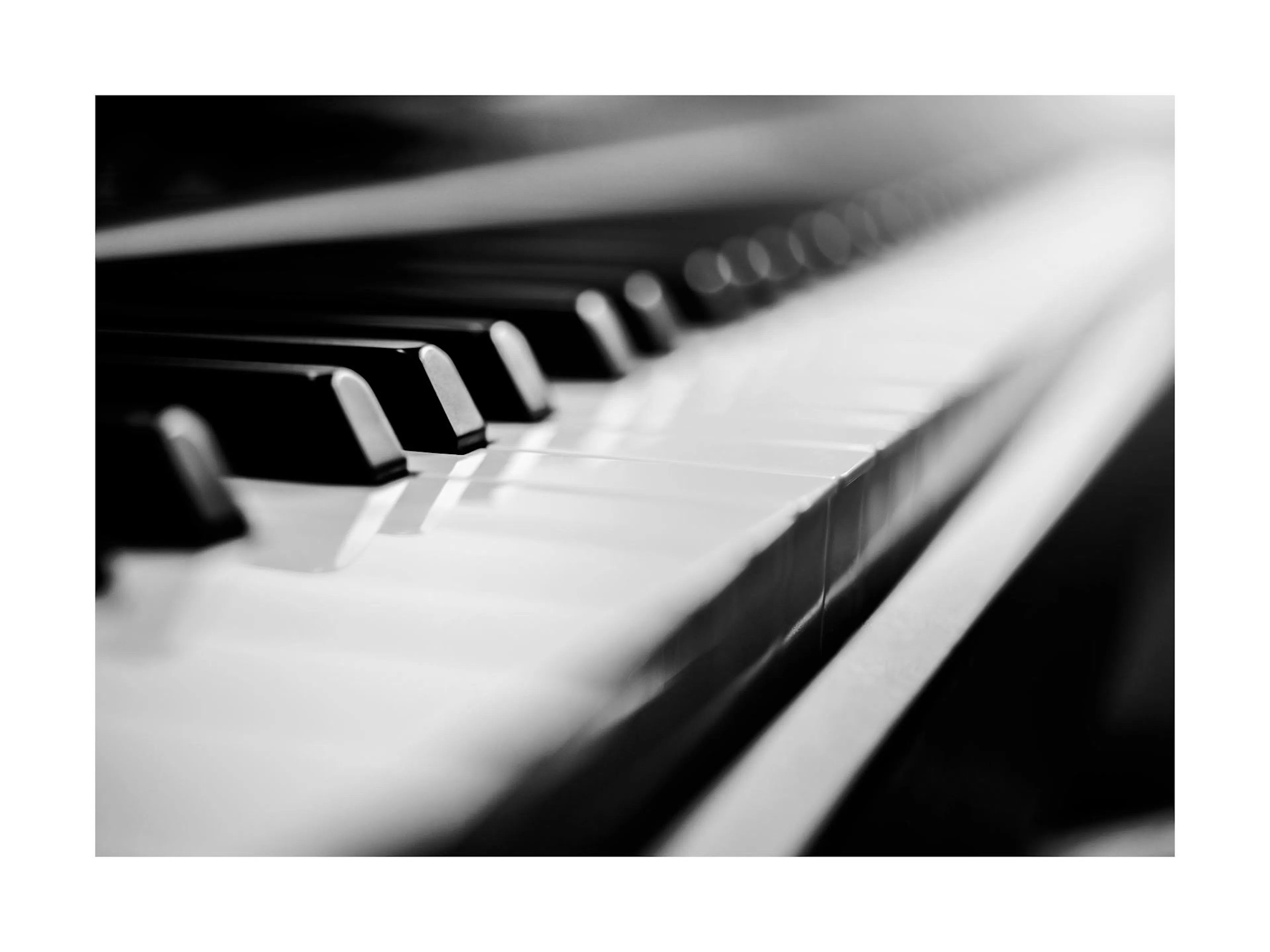 Poster en noir et blanc dun gros plan abstrait des touches dun piano, avec un effet de flou artistique.