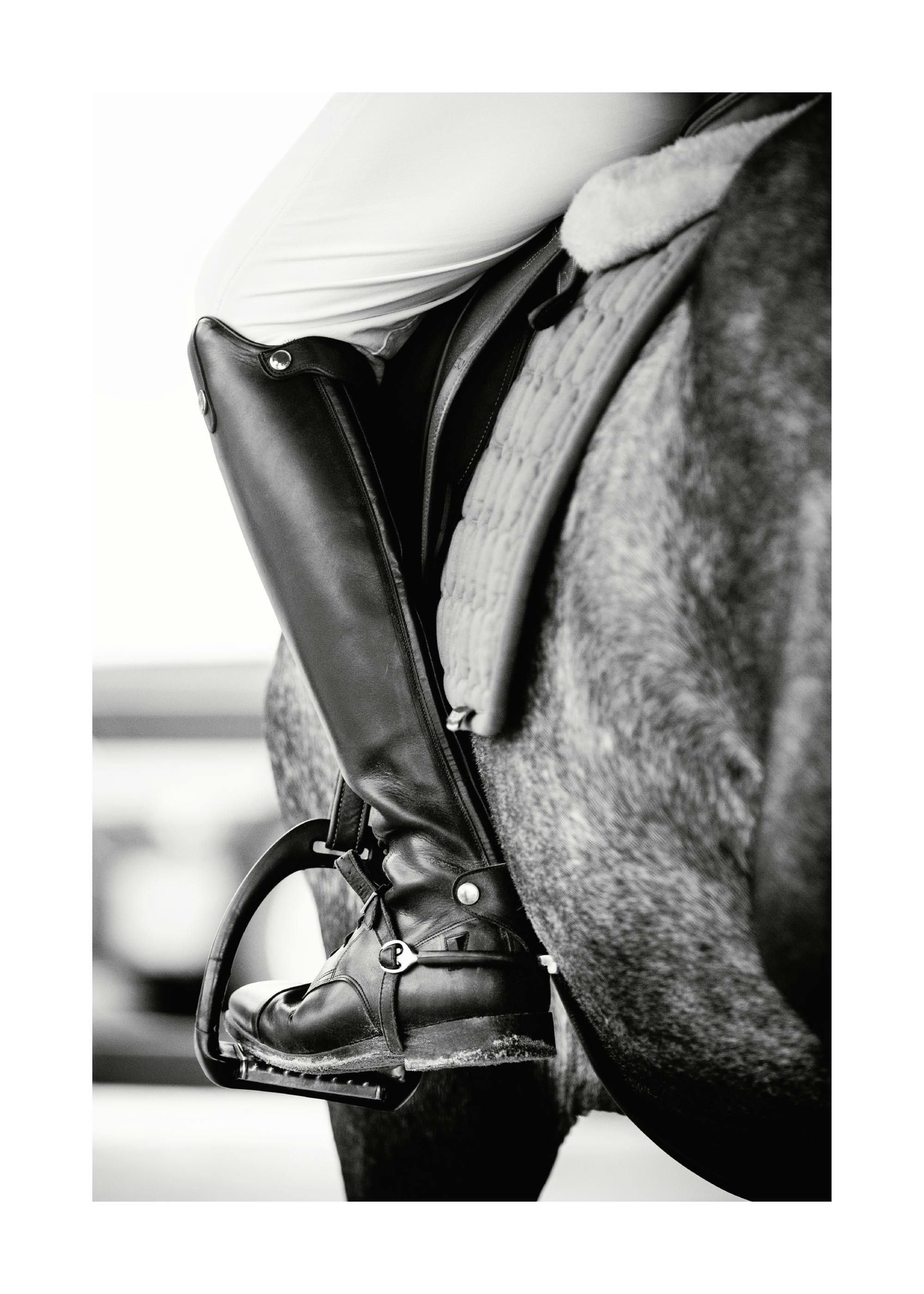 Poster in bianco e nero di uno stivale da equitazione in una staffa su un cavallo.