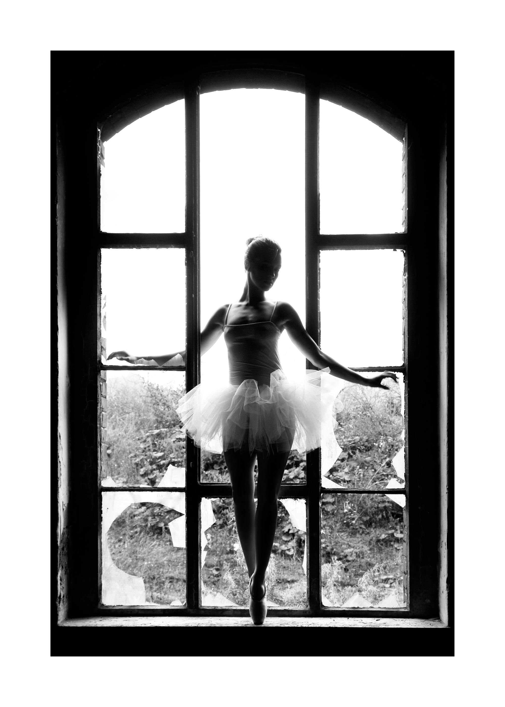 Schwarz-weiß Poster einer Tänzerin als Silhouette in einem Fensterrahmen mit zerbrochenen Scheiben.