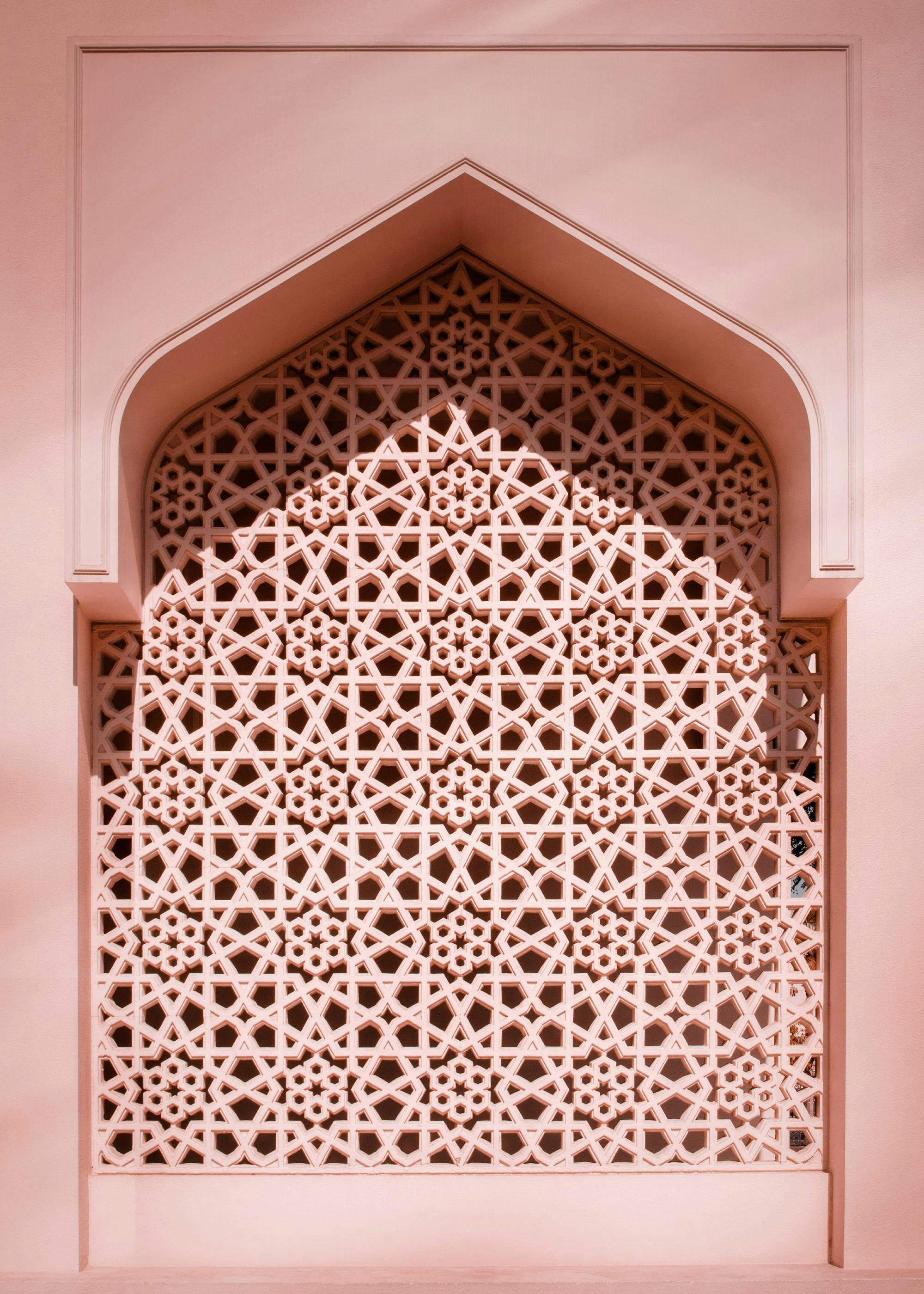 Poster dune fenêtre ornementale rose ornée de motifs géométriques islamiques complexes, avec une arche au-dessus.