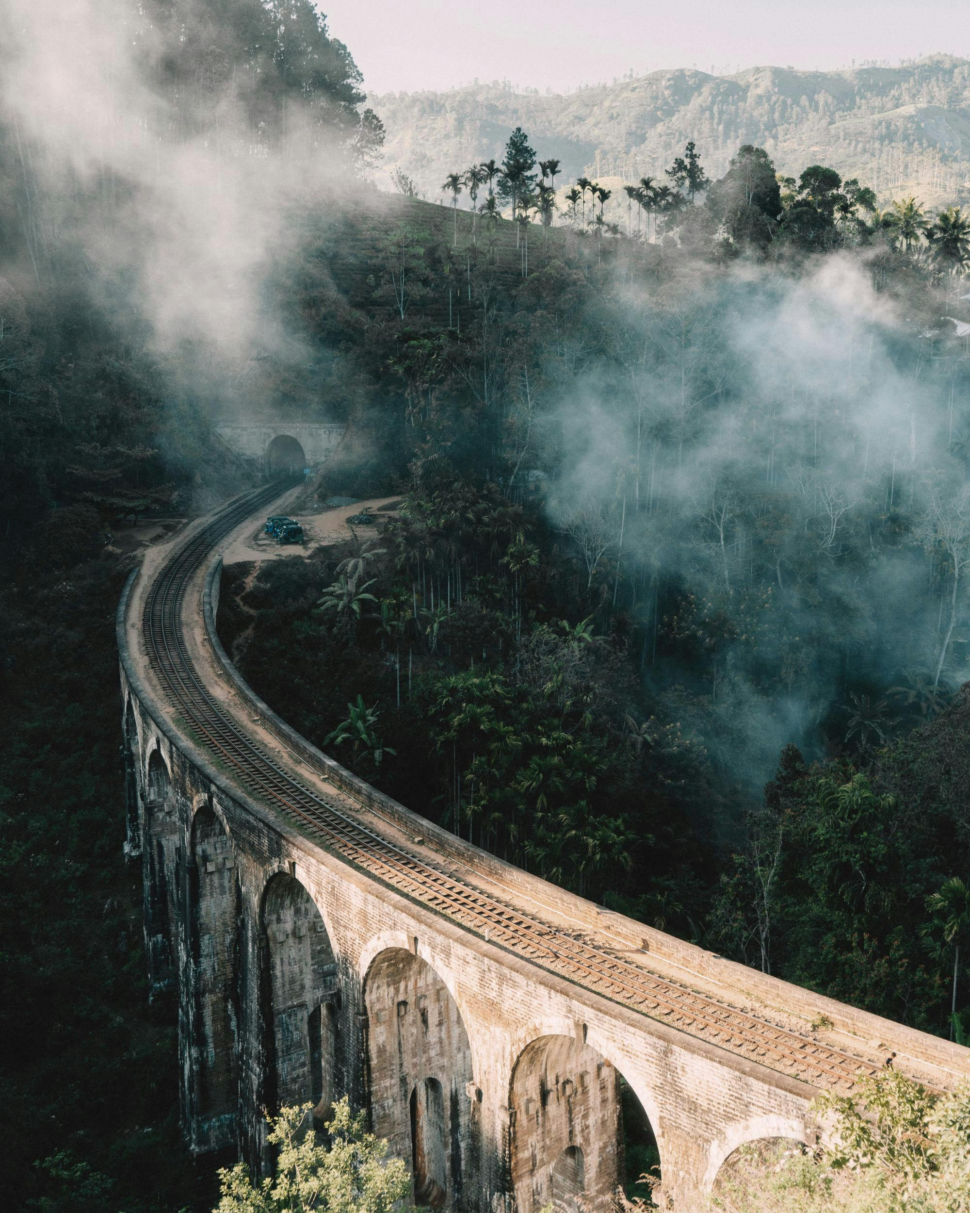 Upea juliste Sri Lankan Nine Arch -sillasta, jota ympäröivät sumuiset kukkulat ja tiheä kasvillisuus.