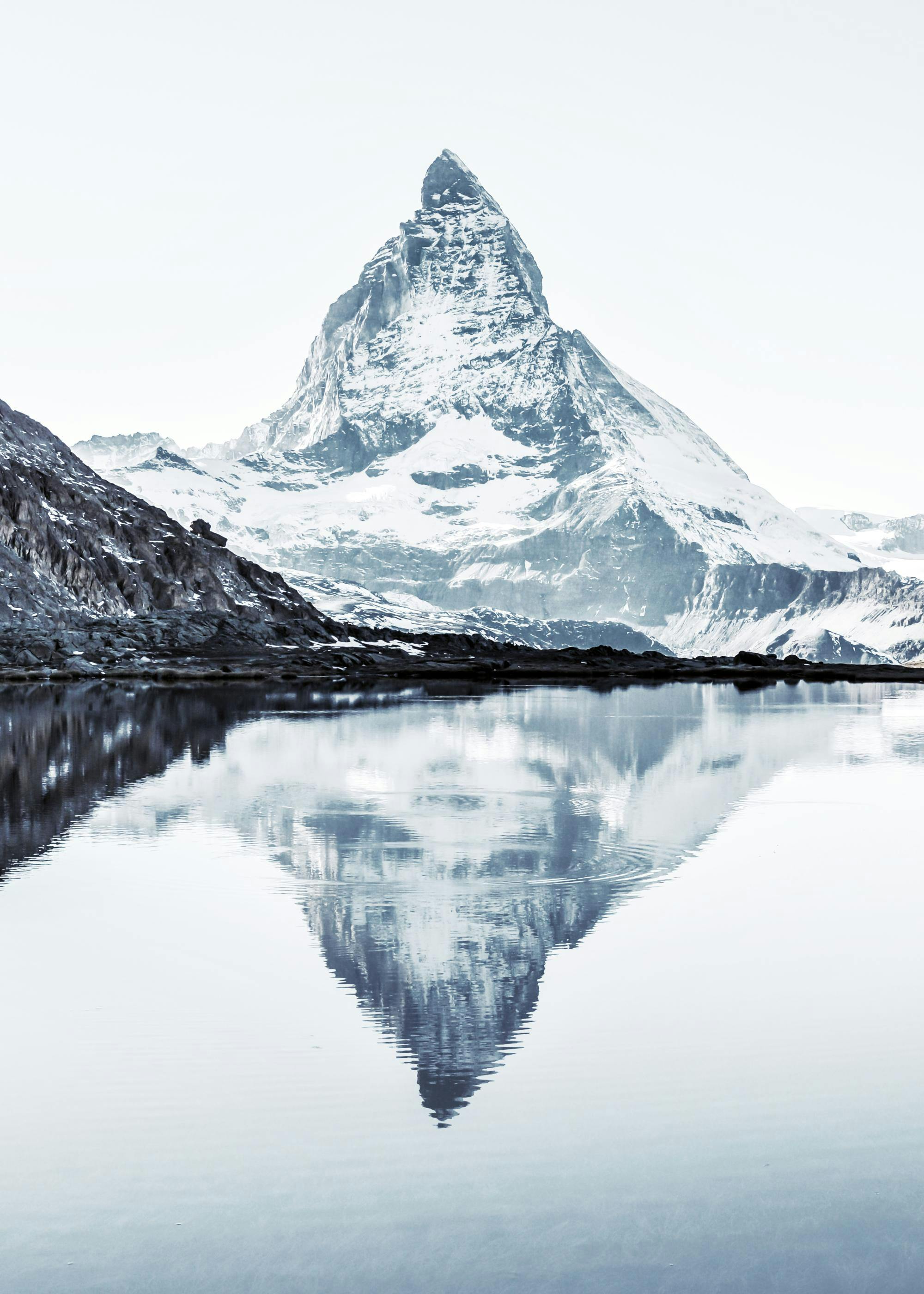 A poster featuring the Matterhorn mountain, snow-capped and reflected clearly in a still lake below.