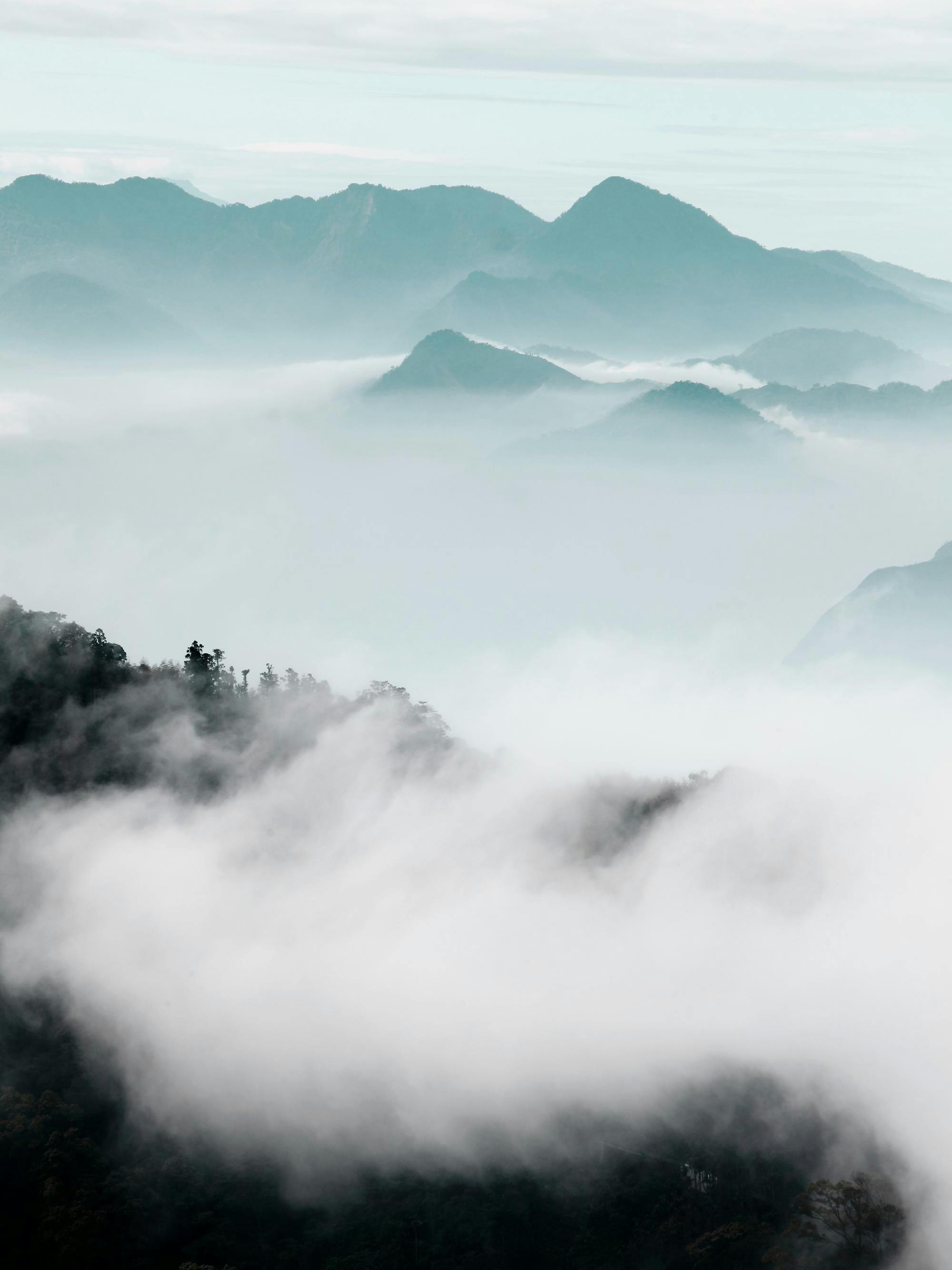 A poster depicting a mystical mountain landscape with dense fog and misty clouds obscuring the peaks.
