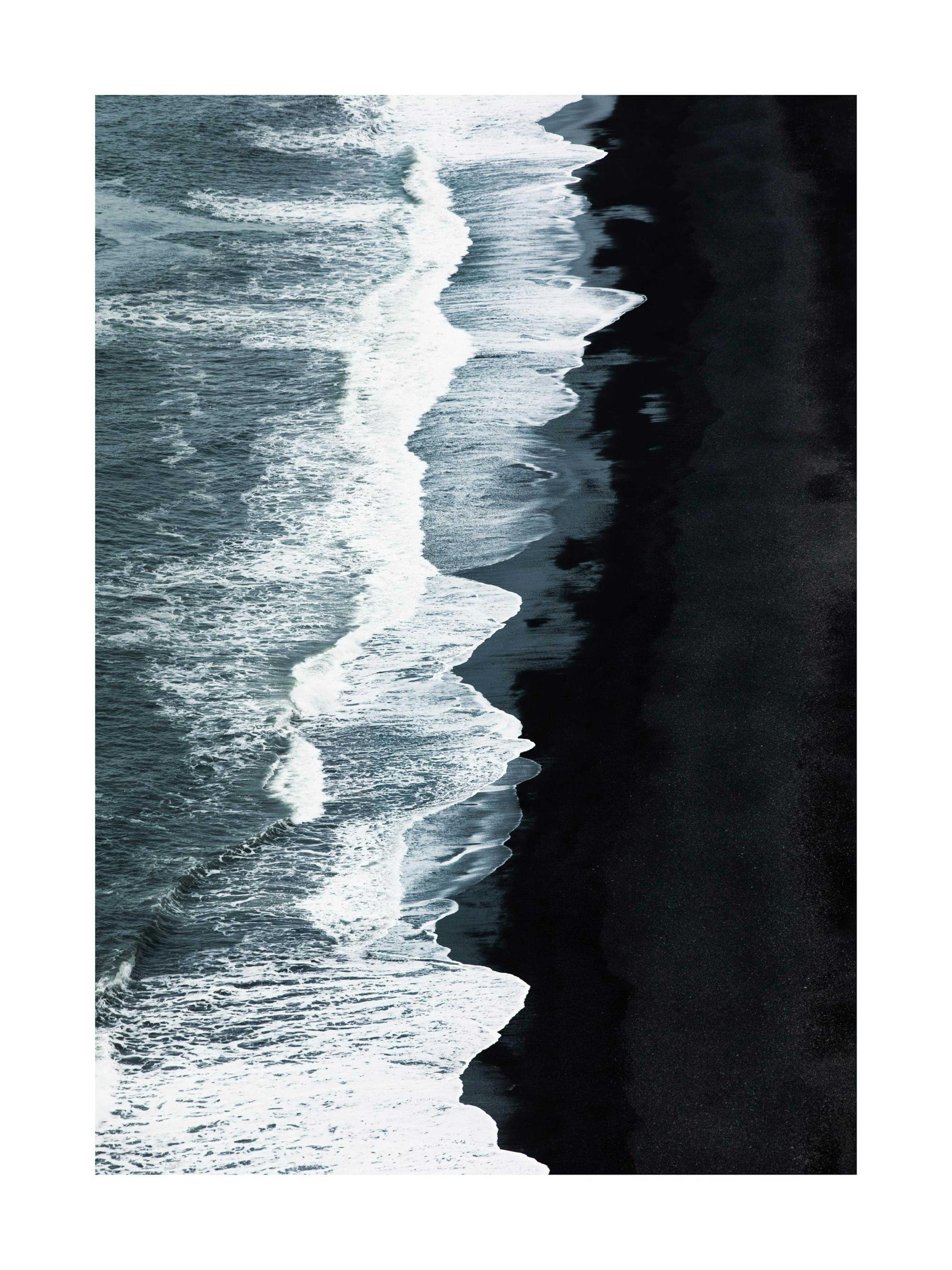 Un póster de olas blancas rompiendo en una playa de arena negra vista desde arriba.