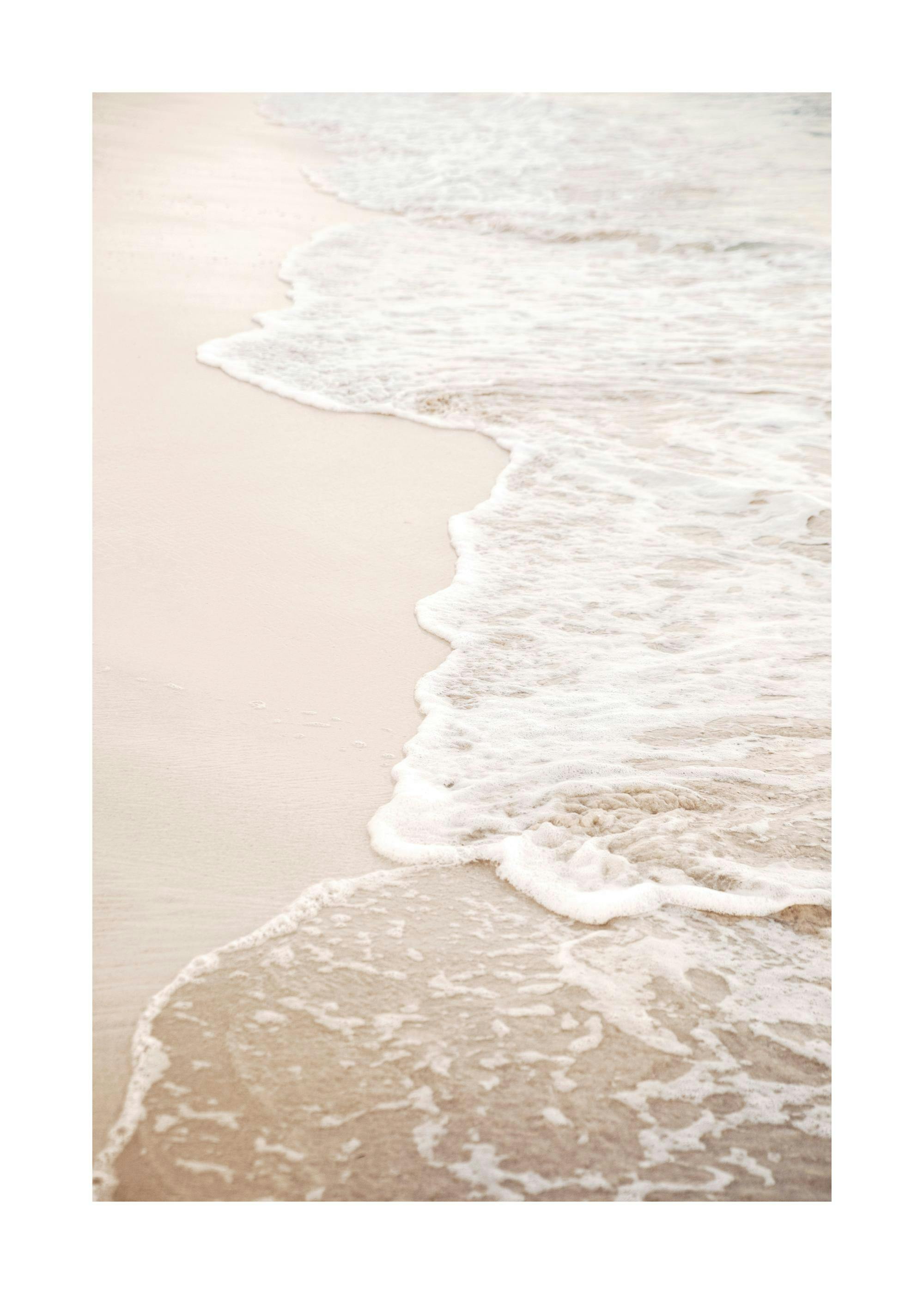 Poster de vagues écumeuses beiges sur une plage de sable clair, un paysage marin apaisant.