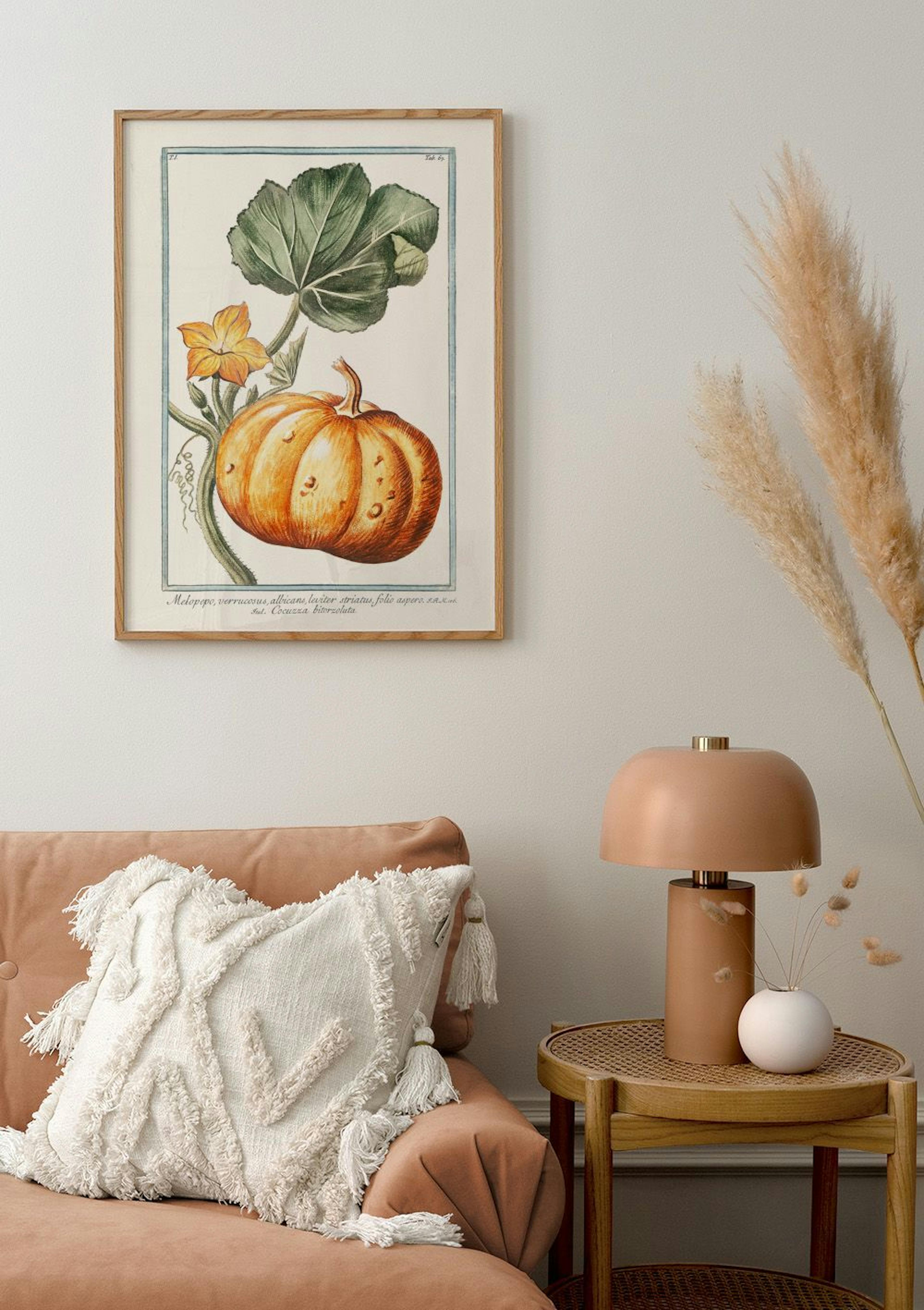 Botanical pumpkin poster with green leaves and yellow flowers, hanging in a living room above a peach sofa.
