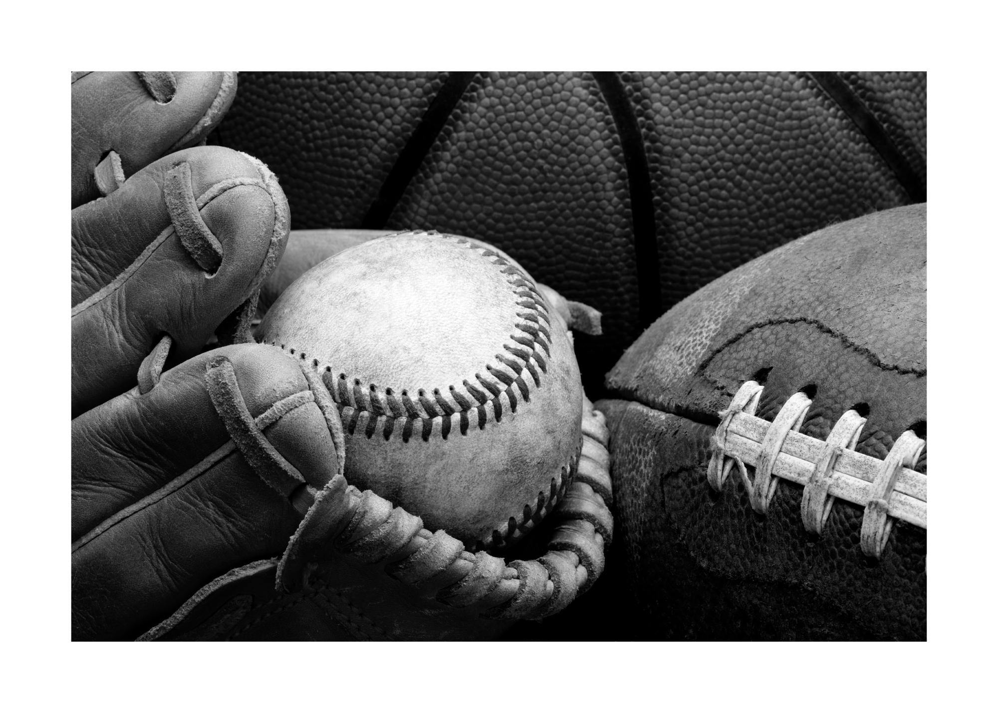 A black and white poster featuring a close-up of sports equipment, including a baseball glove, baseball, and football.