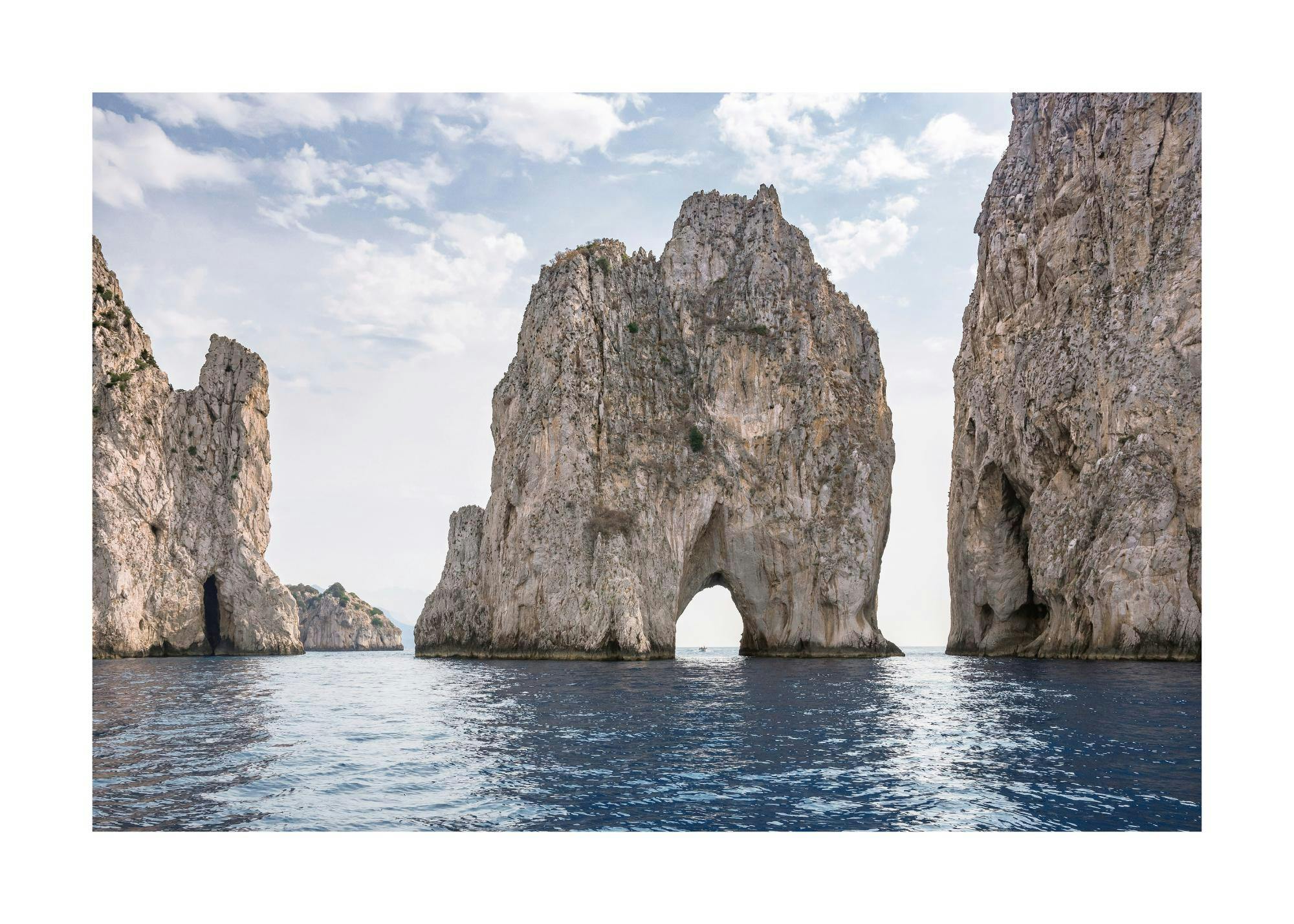 Póster de las formaciones rocosas Faraglioni de Capri en el mar Mediterráneo, con un arco natural.