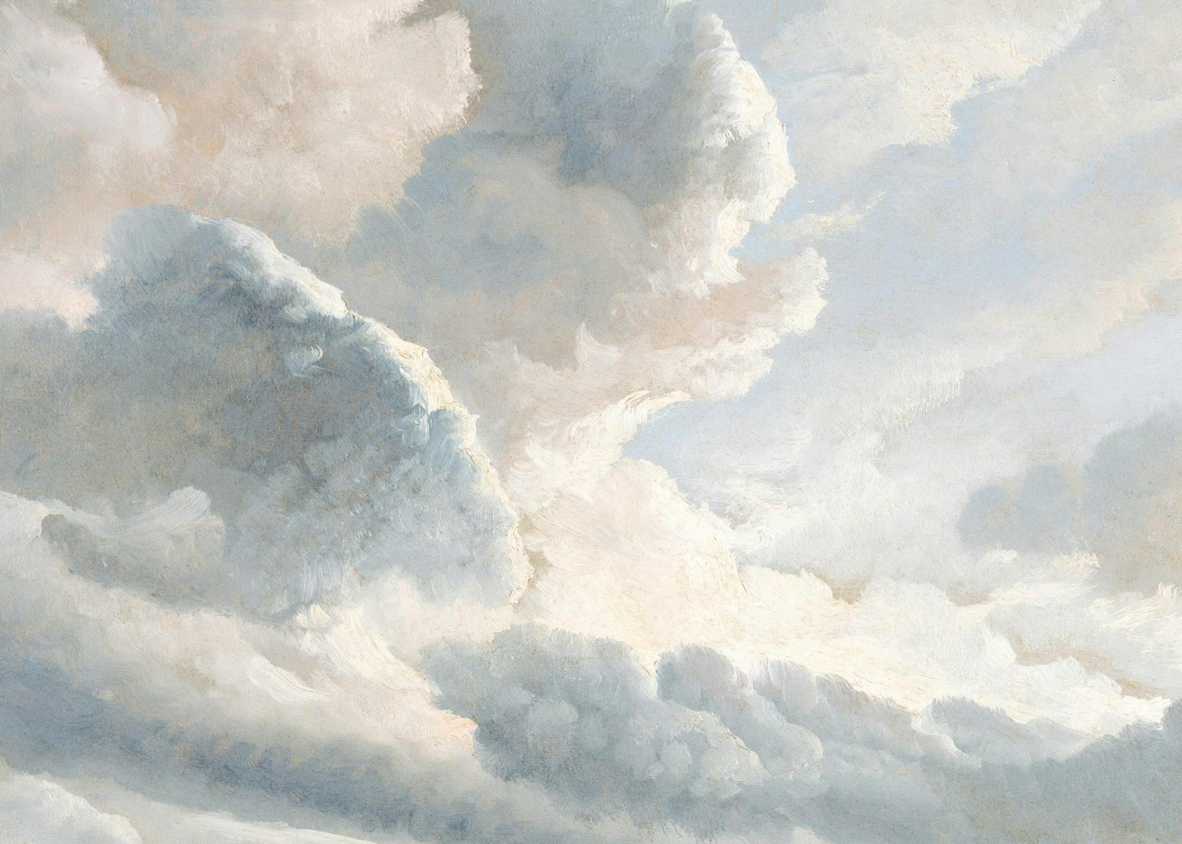 Póster de nubes grises y blancas en un marco de madera, colgado sobre una silla de madera con una manta.