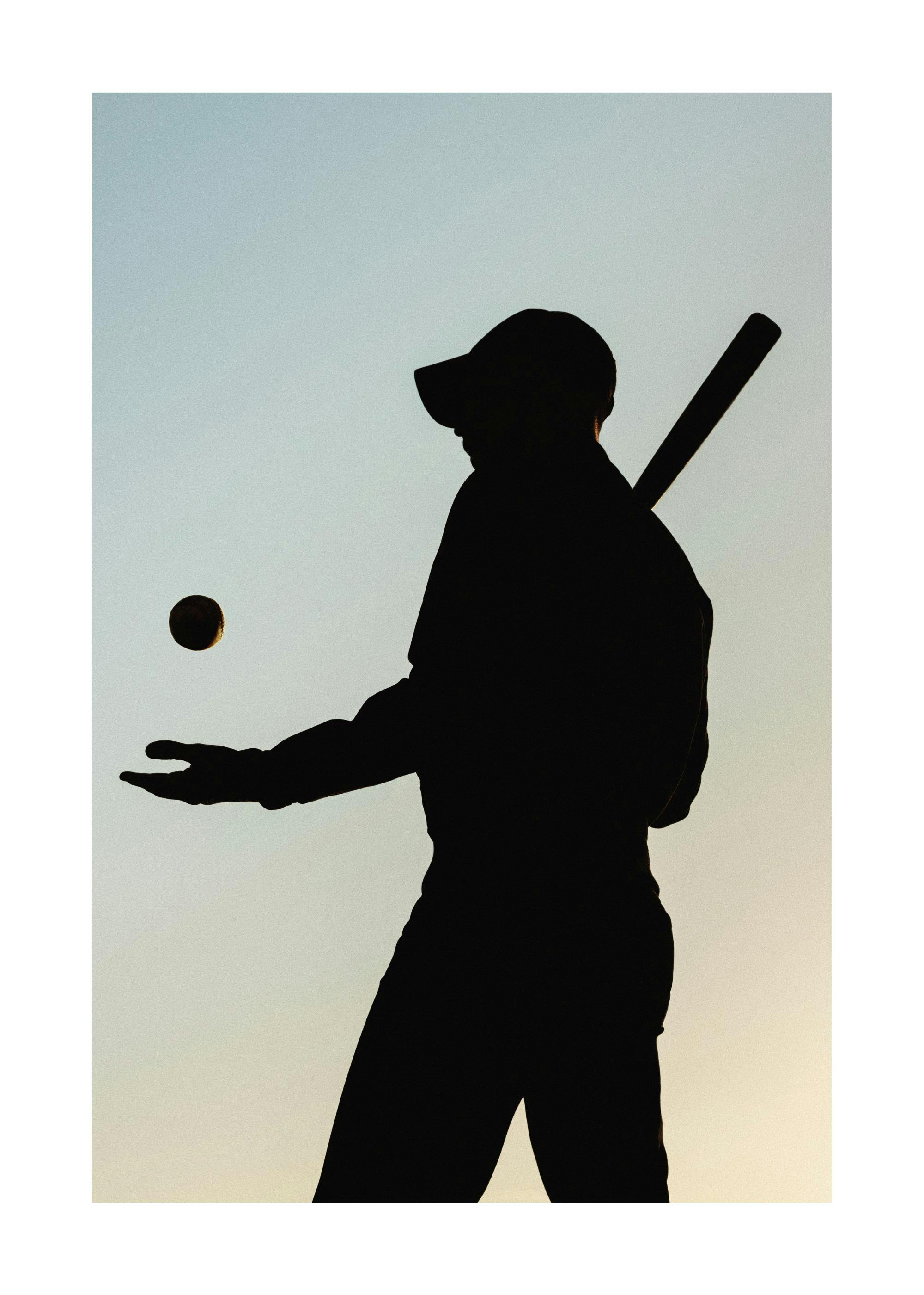 A poster featuring the silhouette of a baseball player wearing a hat, holding a bat, and tossing a ball in the air against a gra