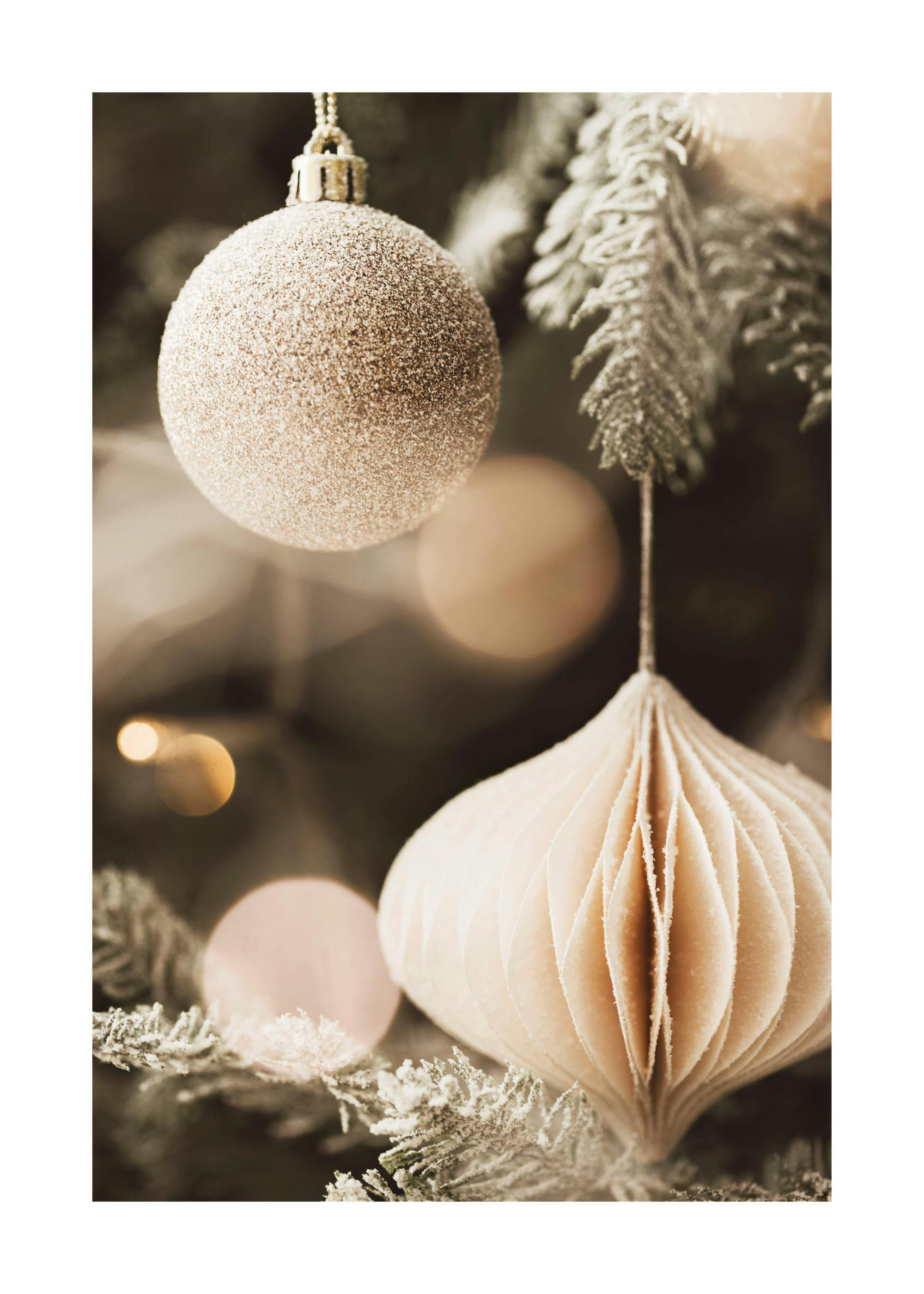A stunning poster featuring a close-up of frosted Christmas ornaments on a snow-dusted tree branch with bokeh lights.