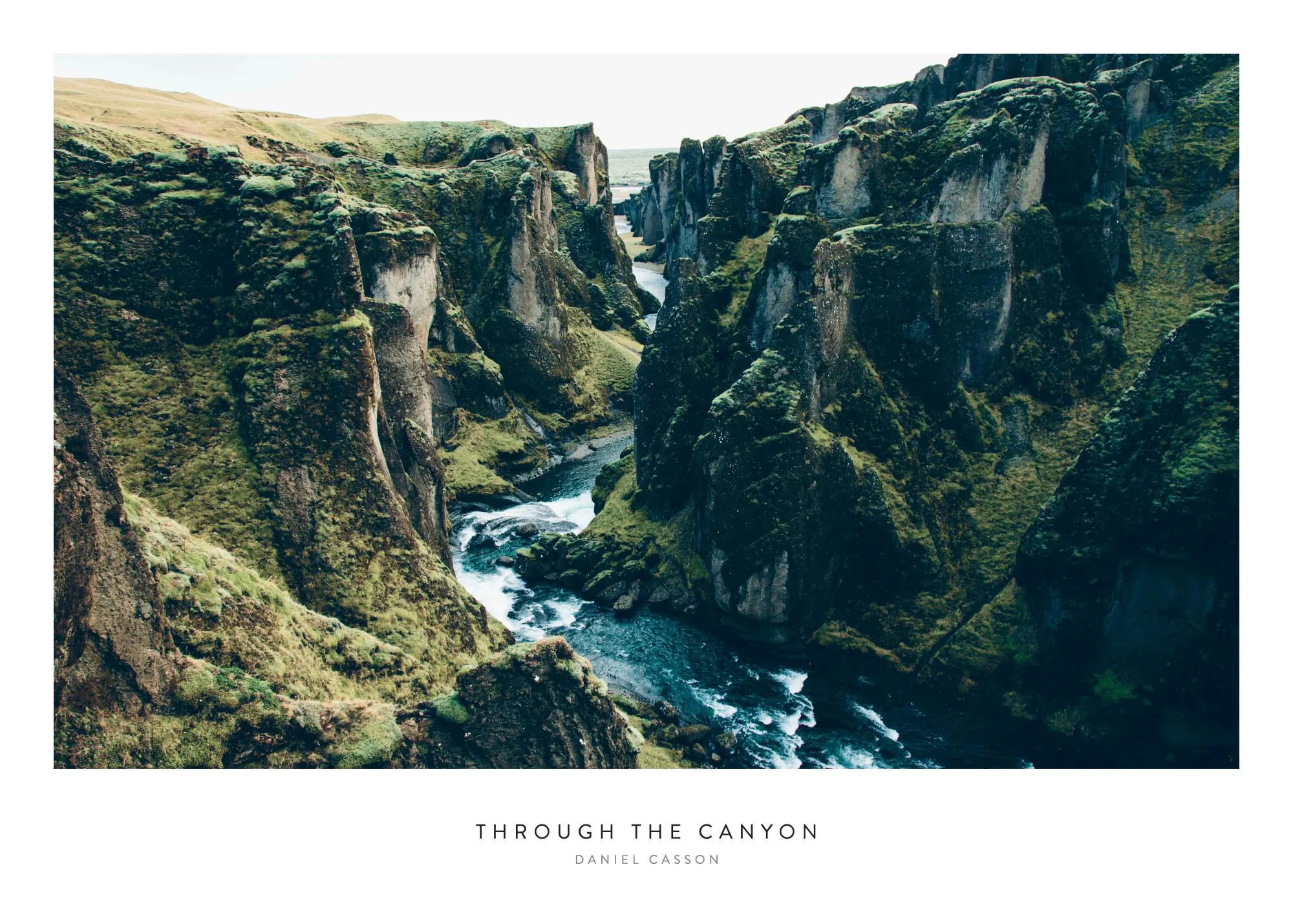 Juliste, jossa näkyy jylhä kanjoni ja virtaava joki, täynnä rehevää vihreää sammalta ja kasvillisuutta.