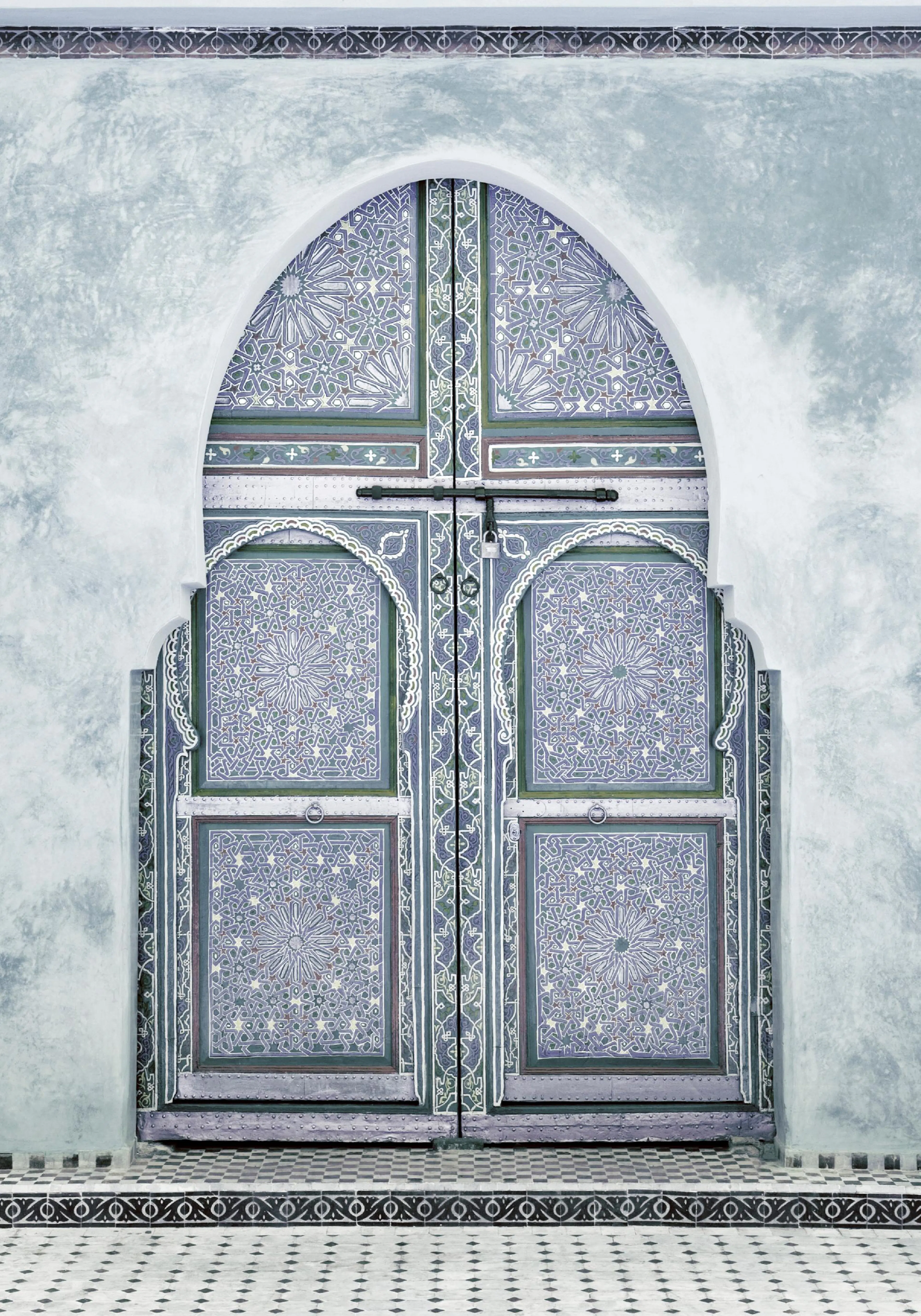 A poster featuring an ornate Moroccan arched door with intricate mosaic patterns in shades of blue and green, set against a ligh