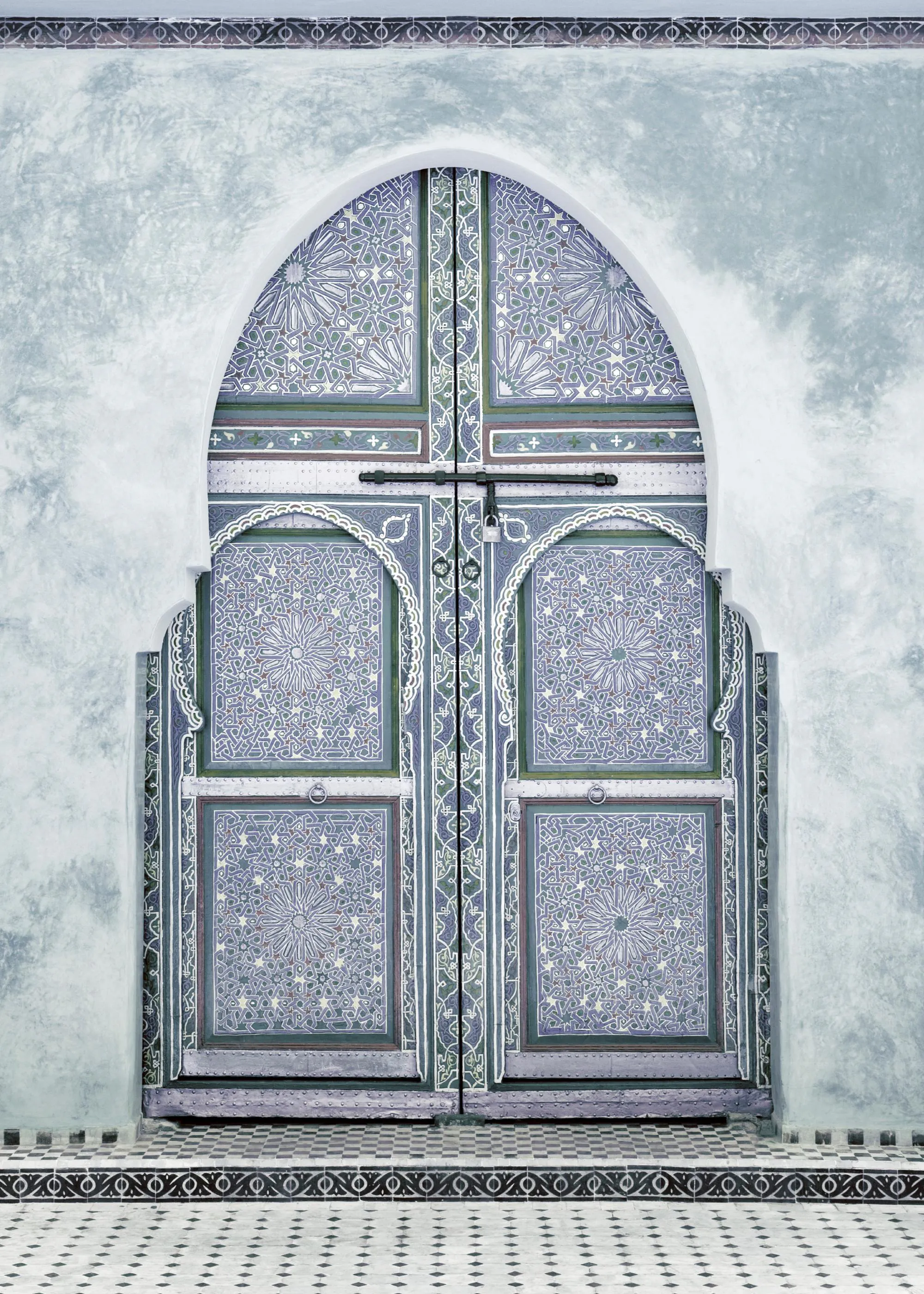 En poster av en marockansk dörröppning med mönstrade dörrar i lila, grönt och vitt.
