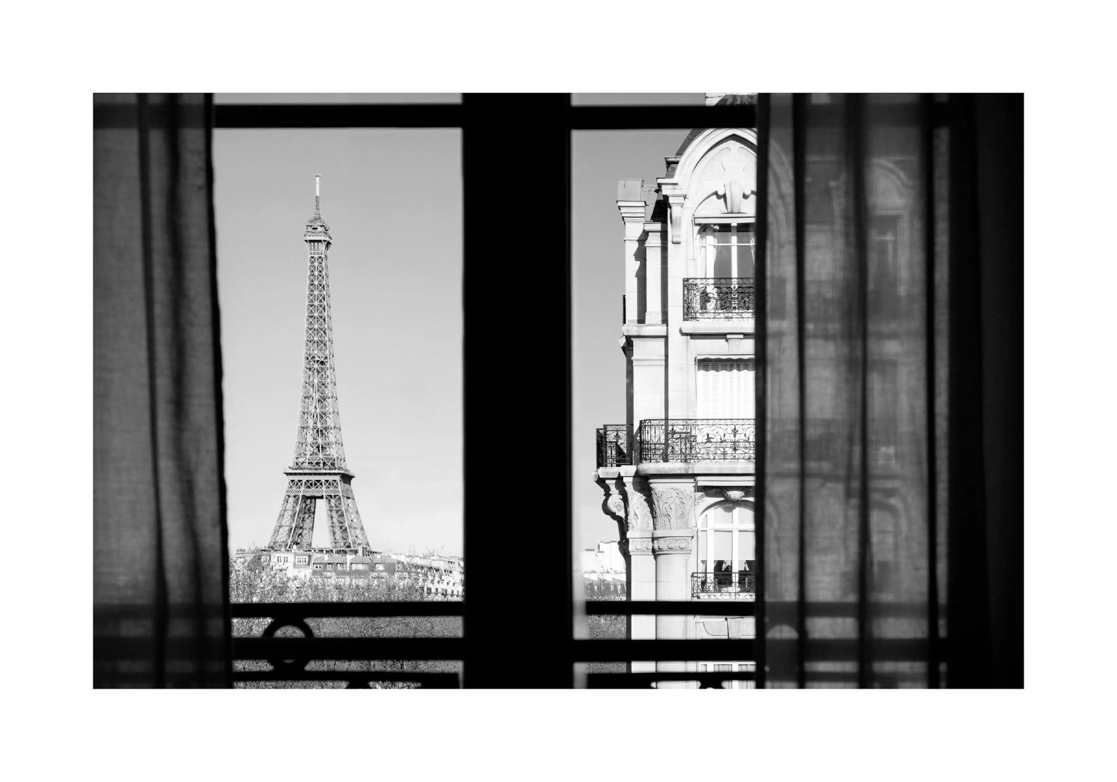 A black and white poster showing a view of the Eiffel Tower and a Paris building through a window with curtains.