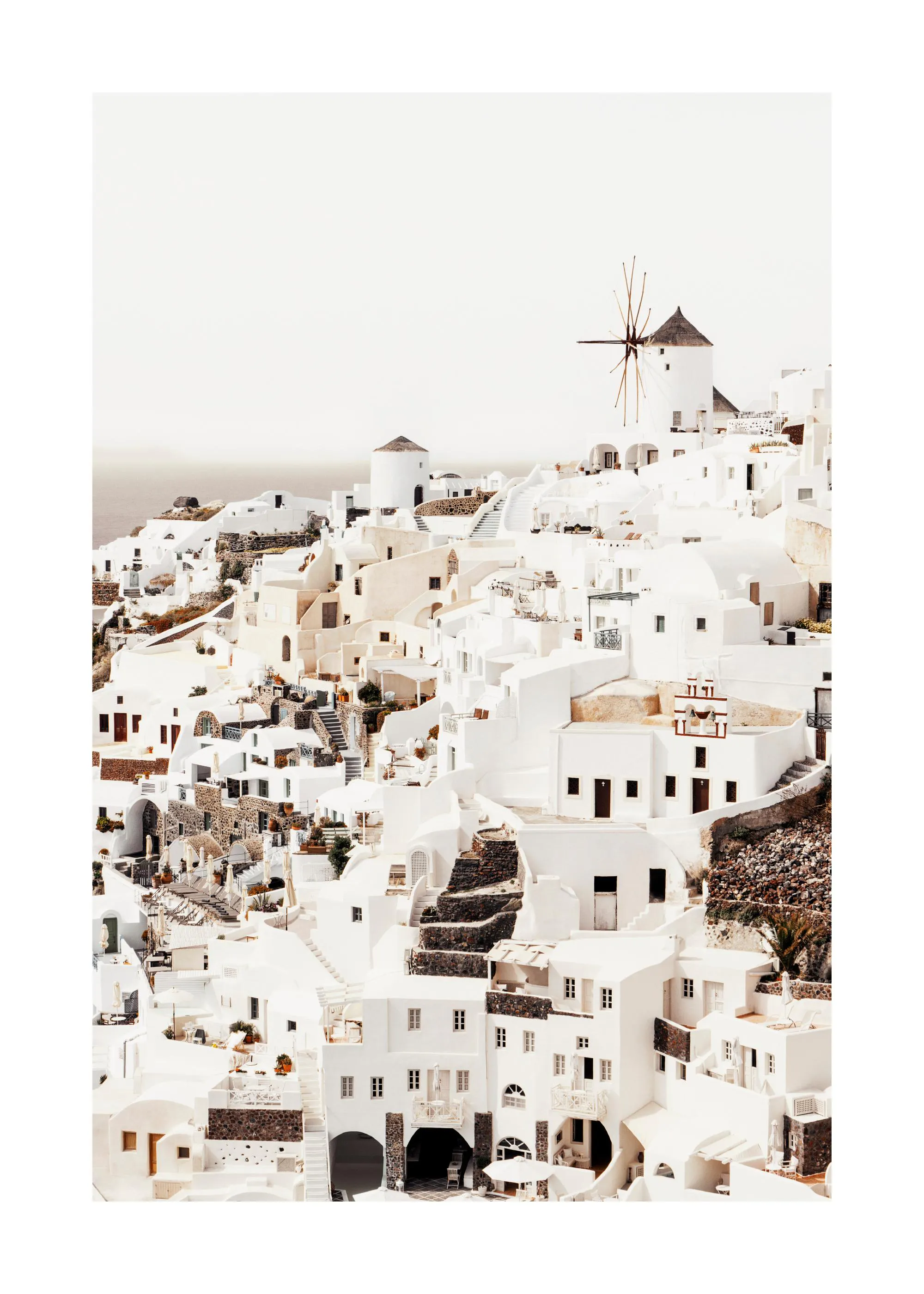 A poster featuring a beautiful landscape of white buildings and windmills on a hill overlooking the sea in Santorini, Greece.