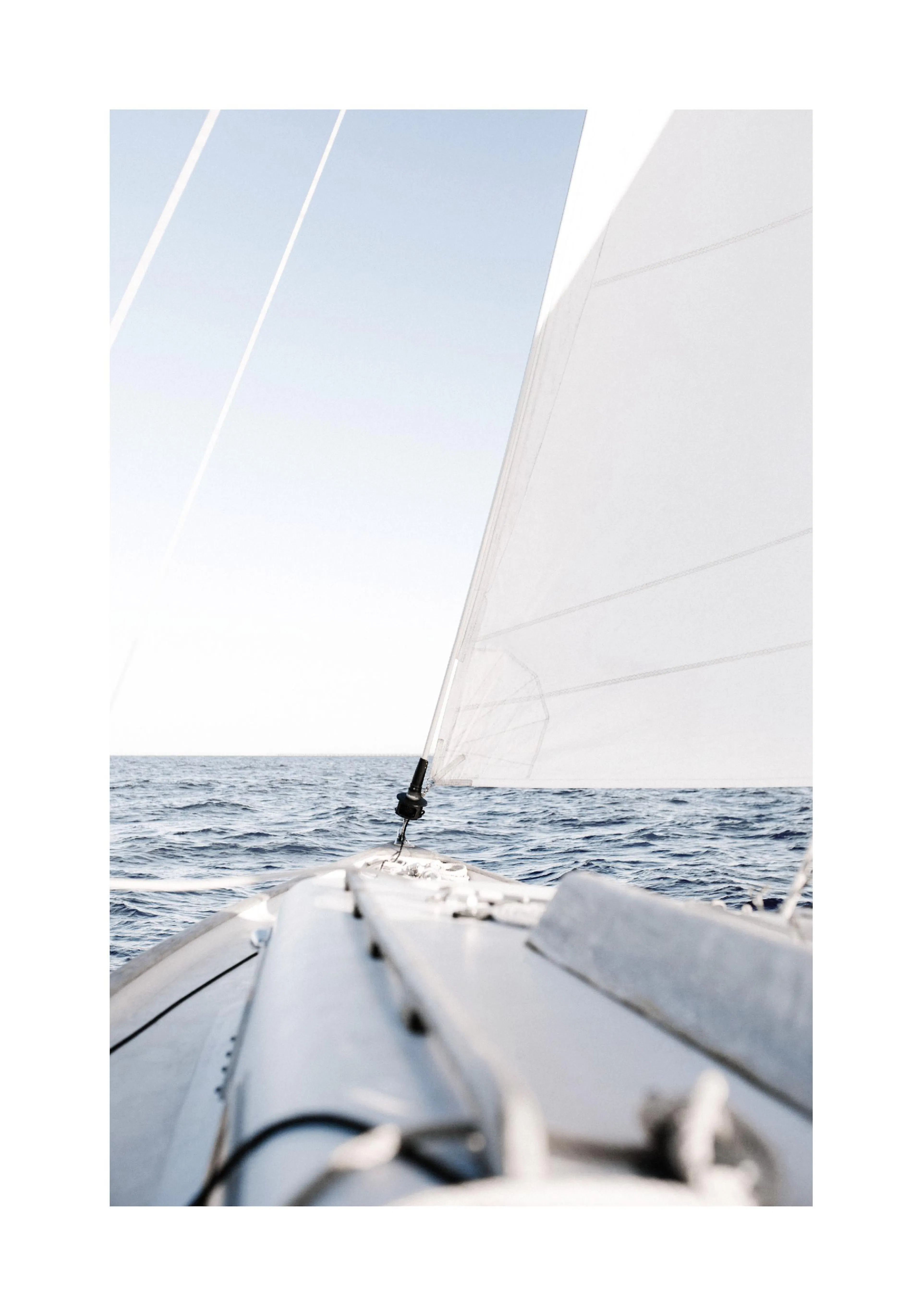 A poster featuring a sailboat on the open ocean, with white sails and the sea in the background under a clear sky.