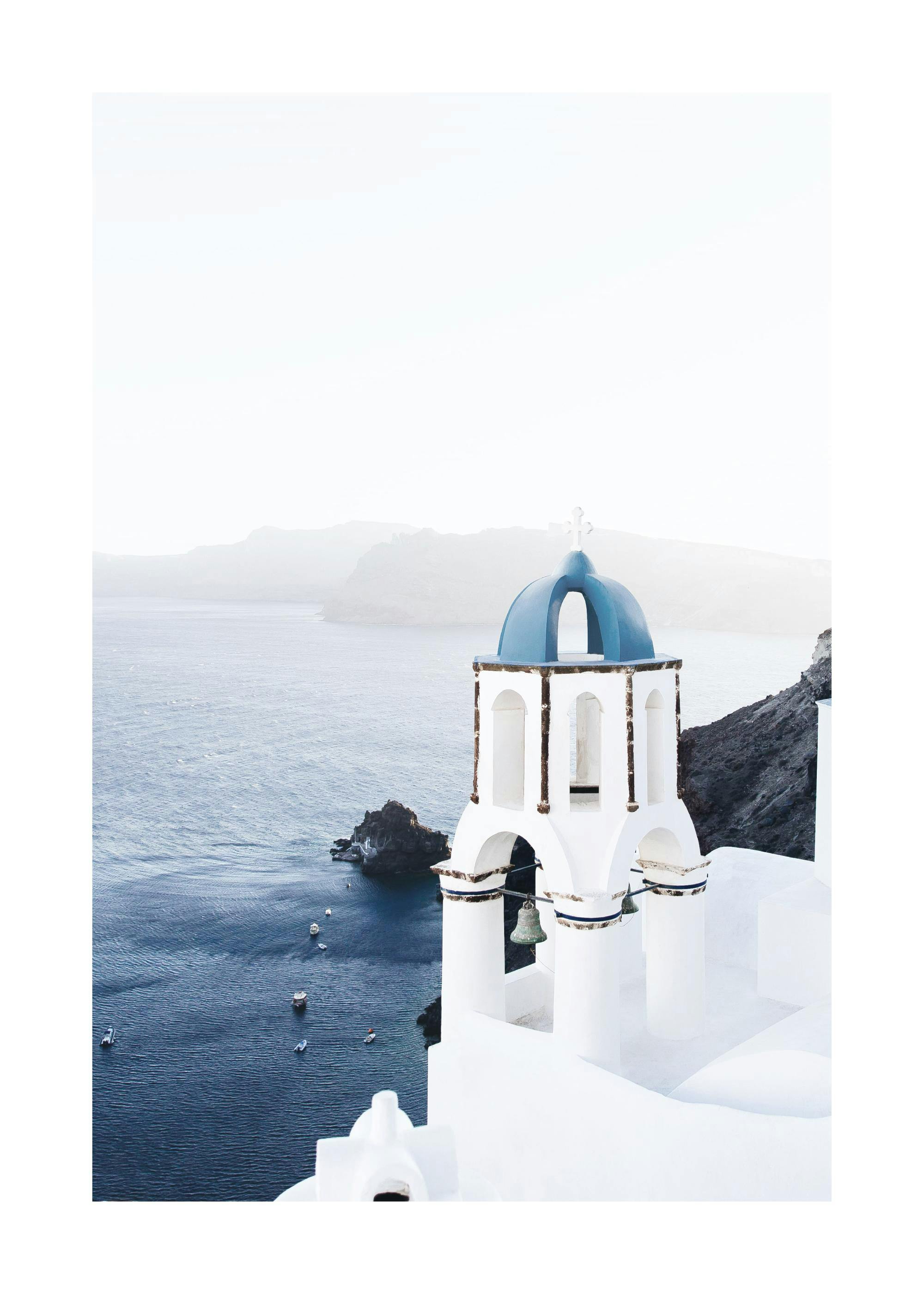 Poster einer weiß getünchten Kirche mit blauer Kuppel über dem Meer und Booten, mit Bergen im Hintergrund.