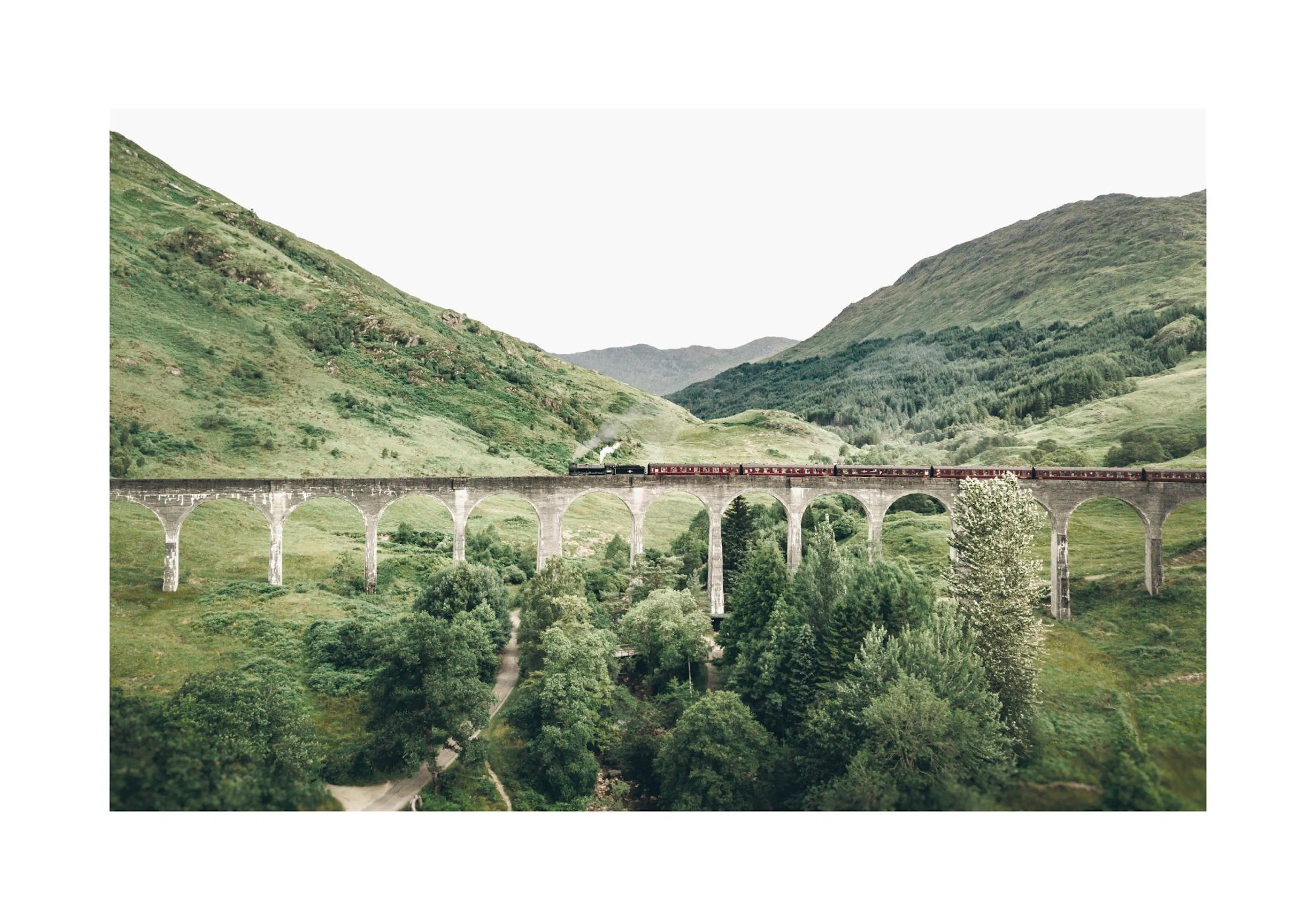 A poster featuring a steam train on a stone viaduct over a lush green valley with mountains.