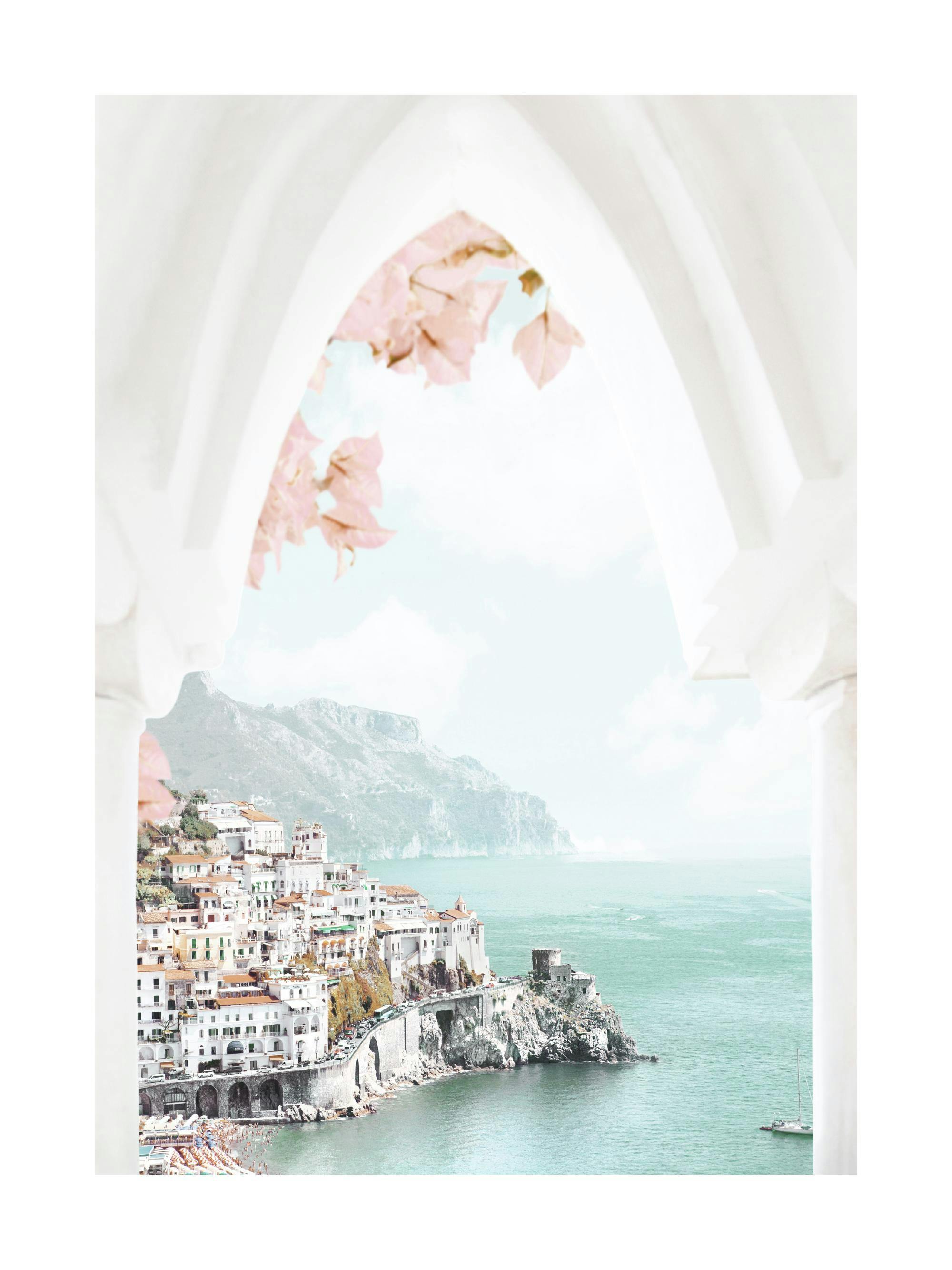 Plakát s pohledem na Amalfi z oblouku s růžovými listy, s bílými domy a tyrkysovým mořem.