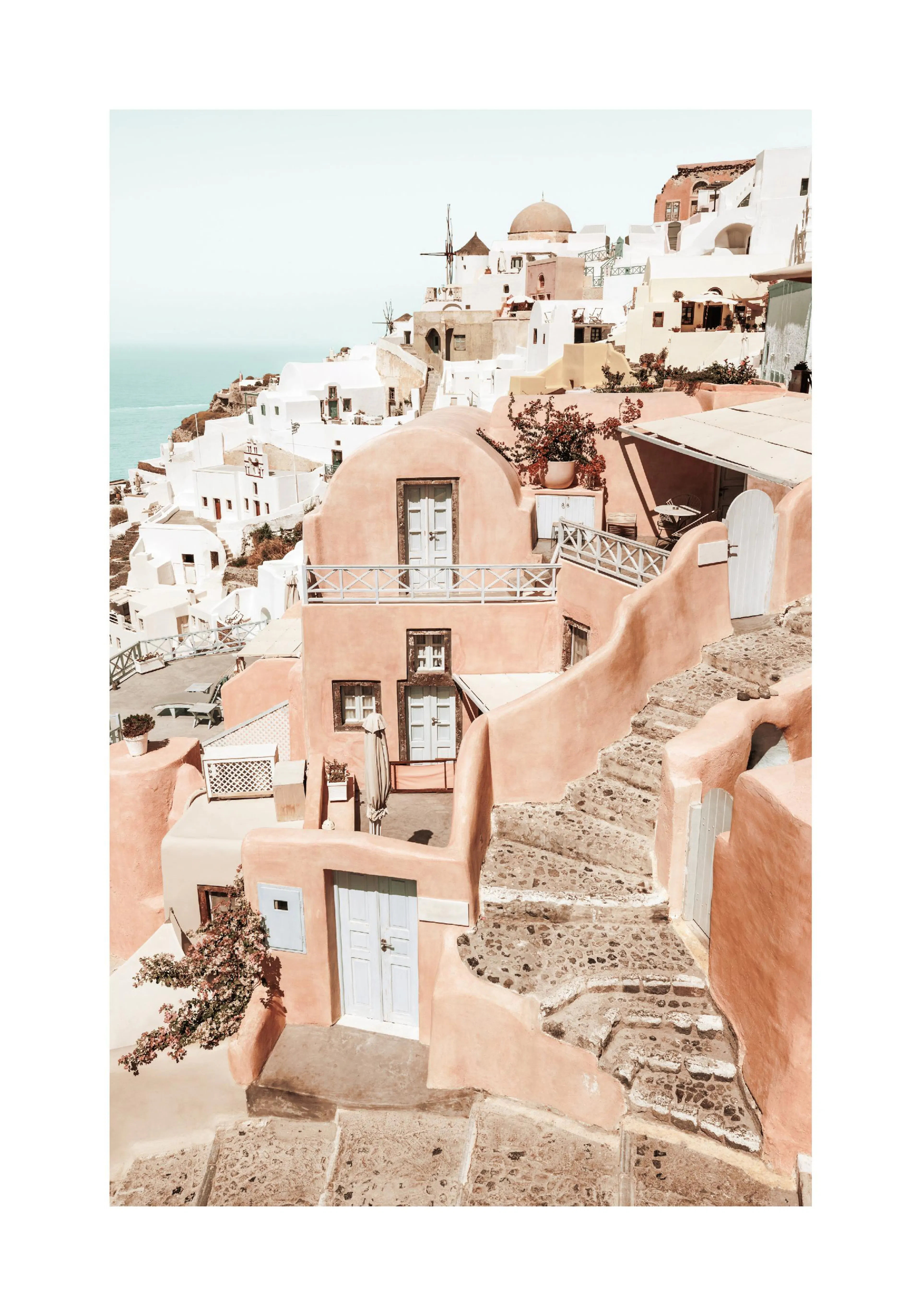 A poster featuring Greek island buildings in Santorini, painted in peach and white, with the ocean visible in the background.