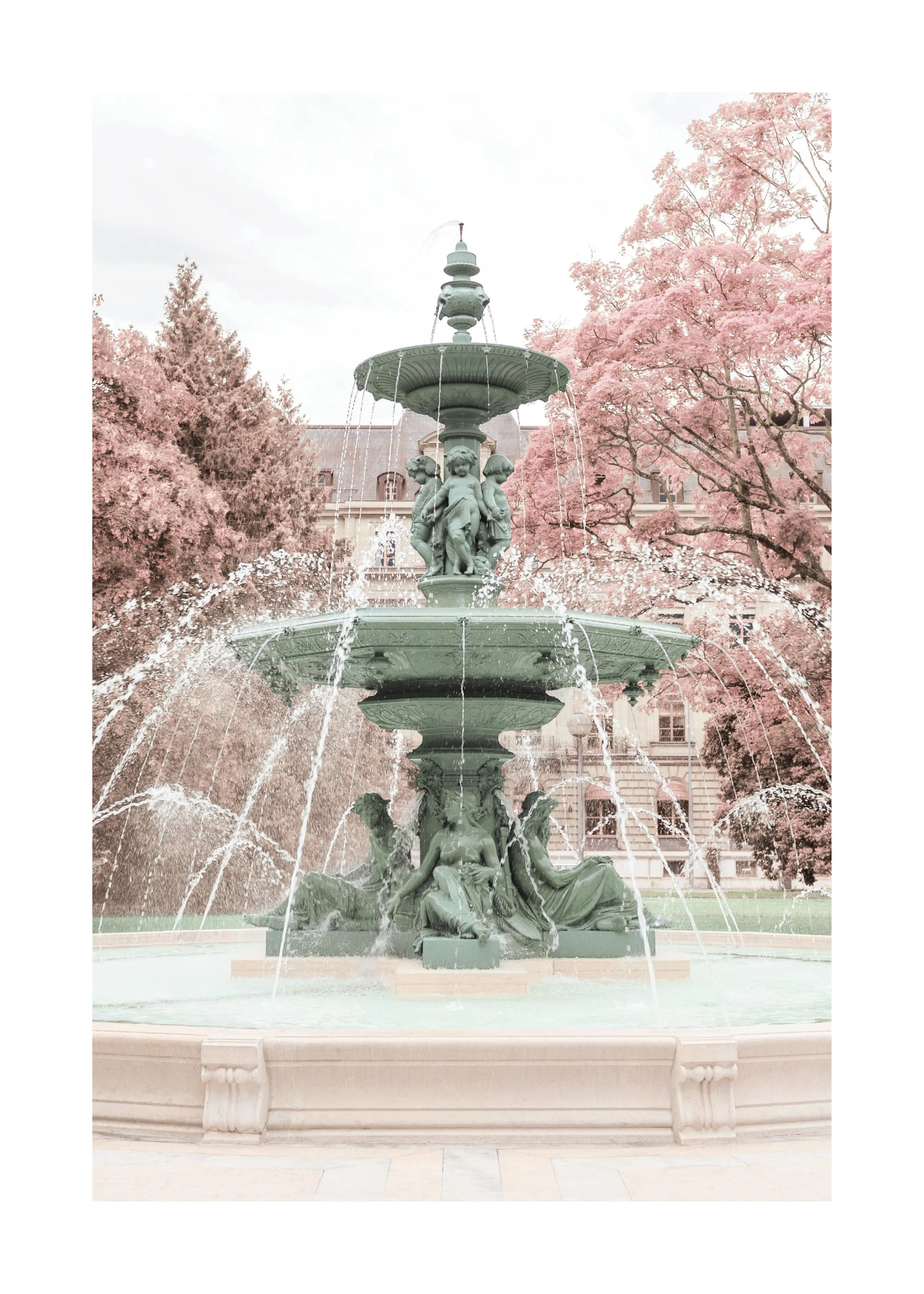 En poster av en grön fontän med statyer och sprutande vatten, omgiven av träd med rosa löv och en byggnad i bakgrunden.