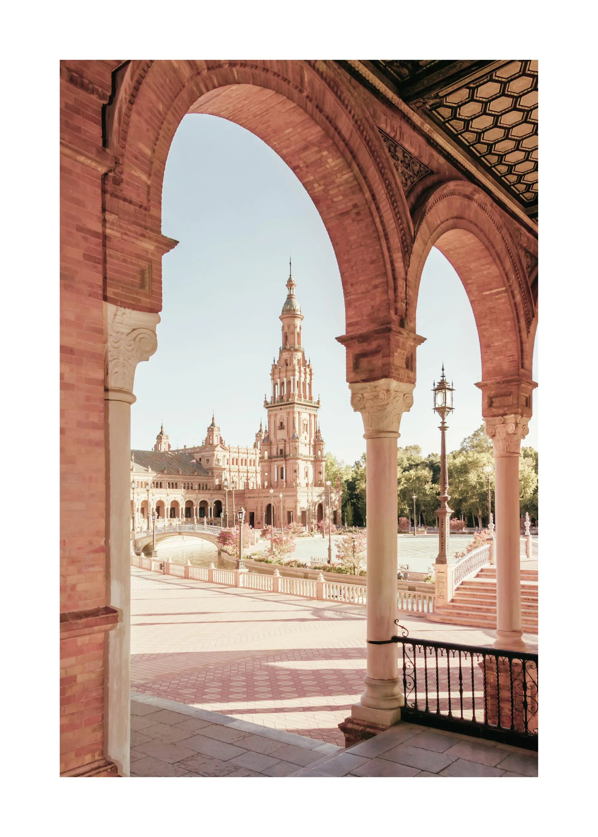 En poster som visar en vy genom romerska valv mot en historisk byggnad med ett högt torn, omgiven av träd och en bro över en kan