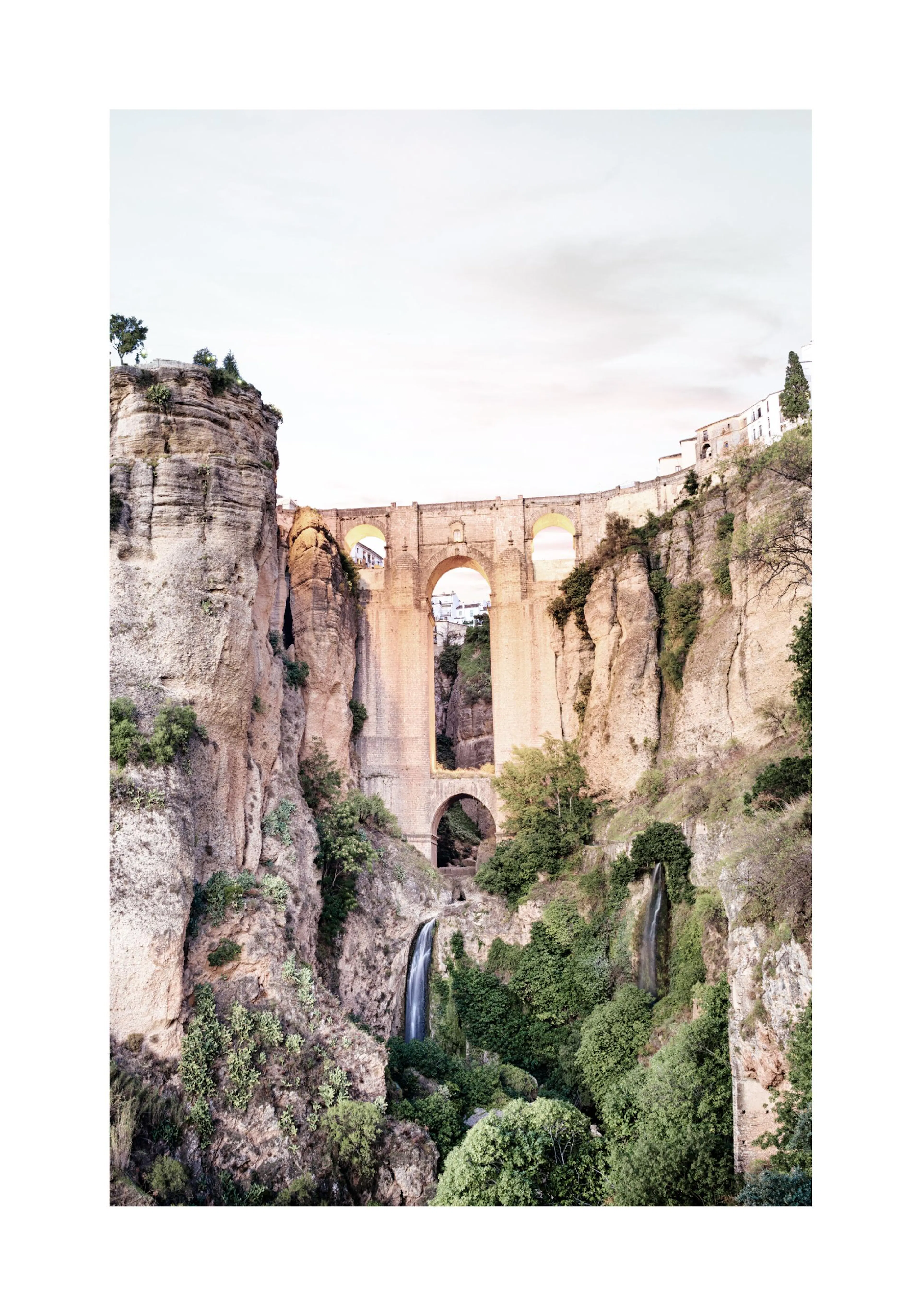Poster con il Ponte Nuovo di Ronda, Spagna, che attraversa una gola rocciosa con cascate e vegetazione.