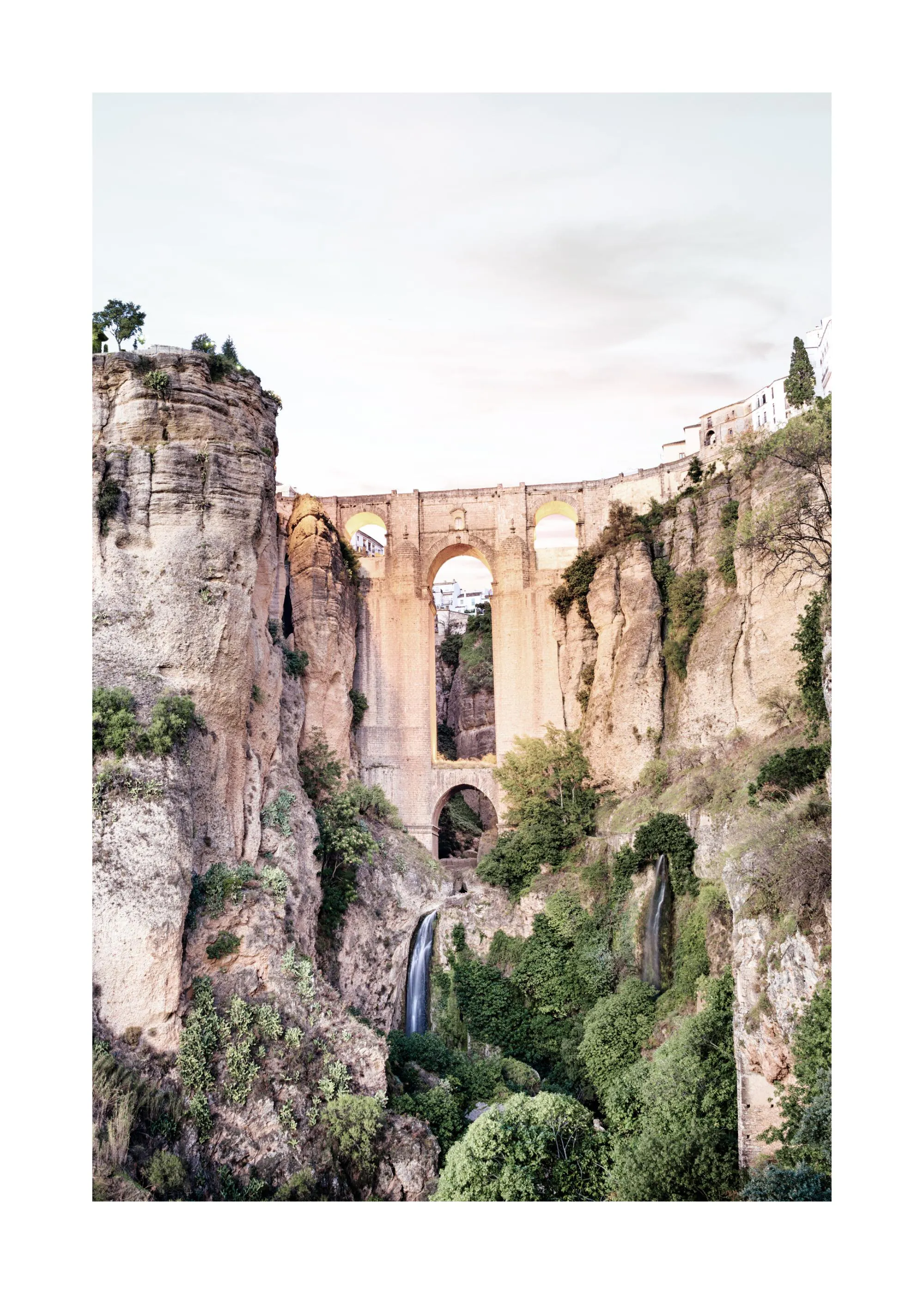 Poster con il Ponte Nuovo di Ronda, Spagna, che attraversa una gola rocciosa con cascate e vegetazione.