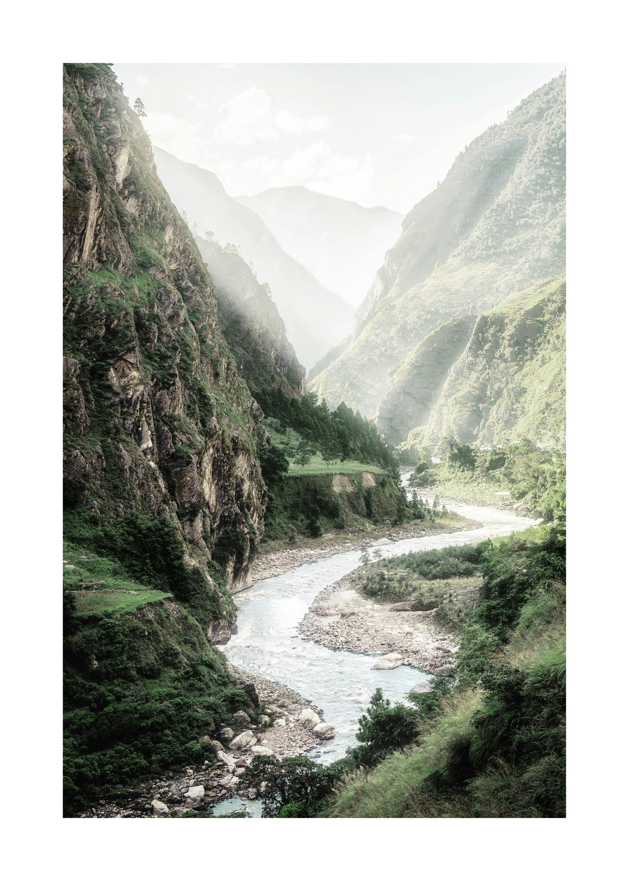 Un poster dune rivière serpentant à travers une vallée de montagne brumeuse et verdoyante sous un ciel lumineux.