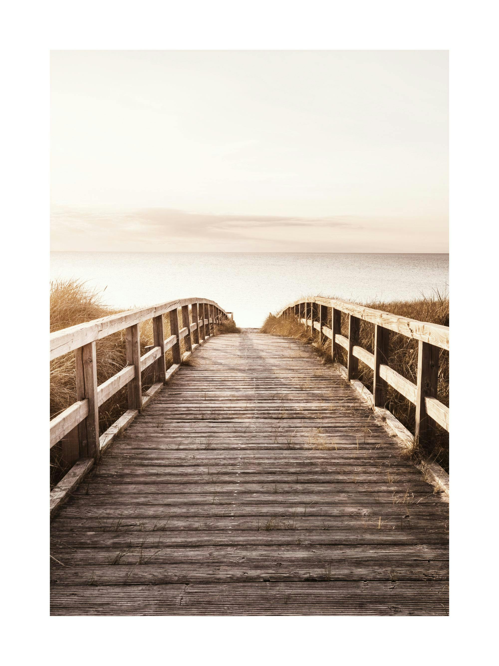 A poster featuring a wooden boardwalk over sand dunes leading to a calm sea under a soft, clear sky.