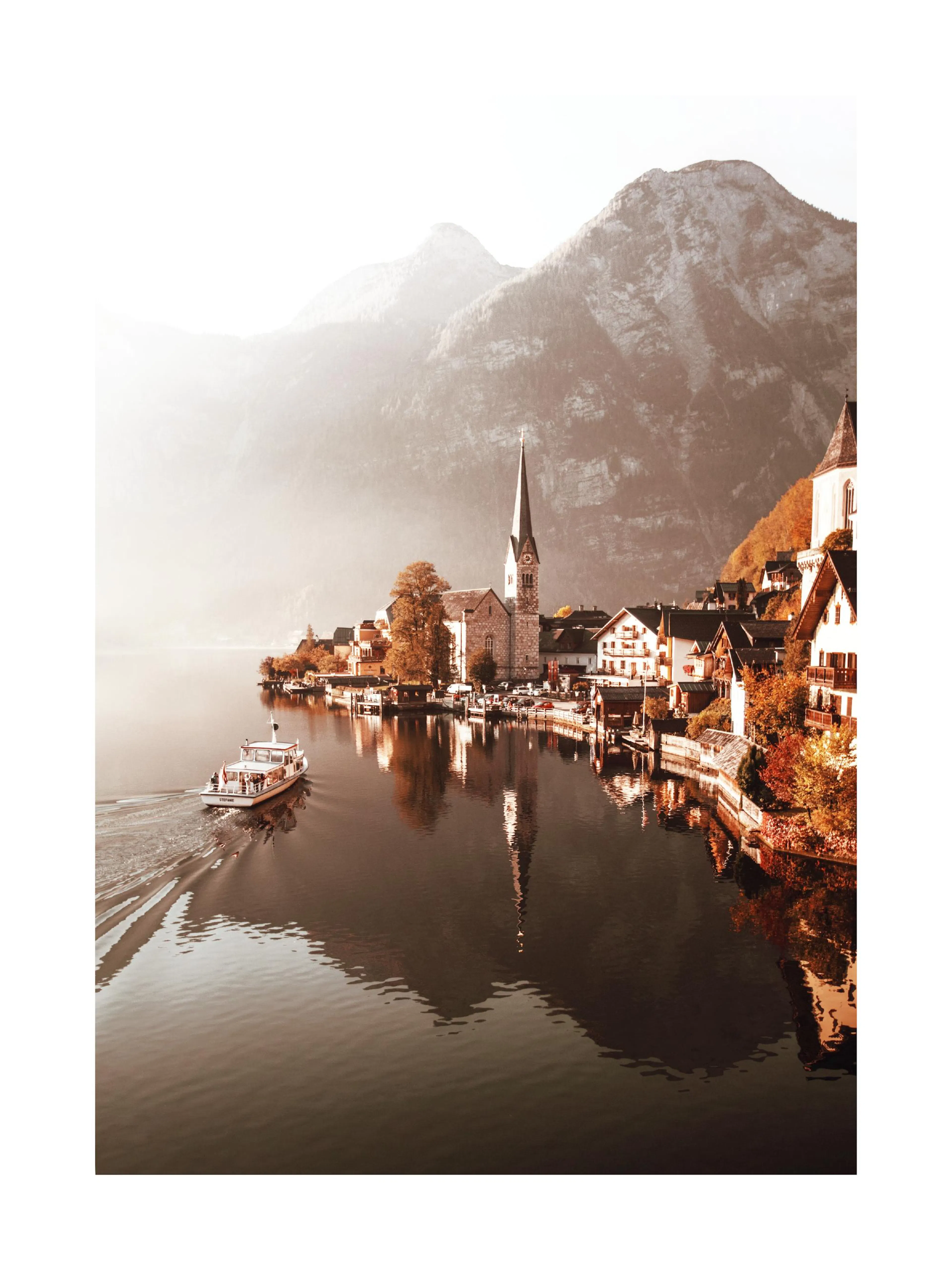 Plakát s pohledem na Hallstatt u jezera s plující lodí, obklopený horami a podzimními stromy.